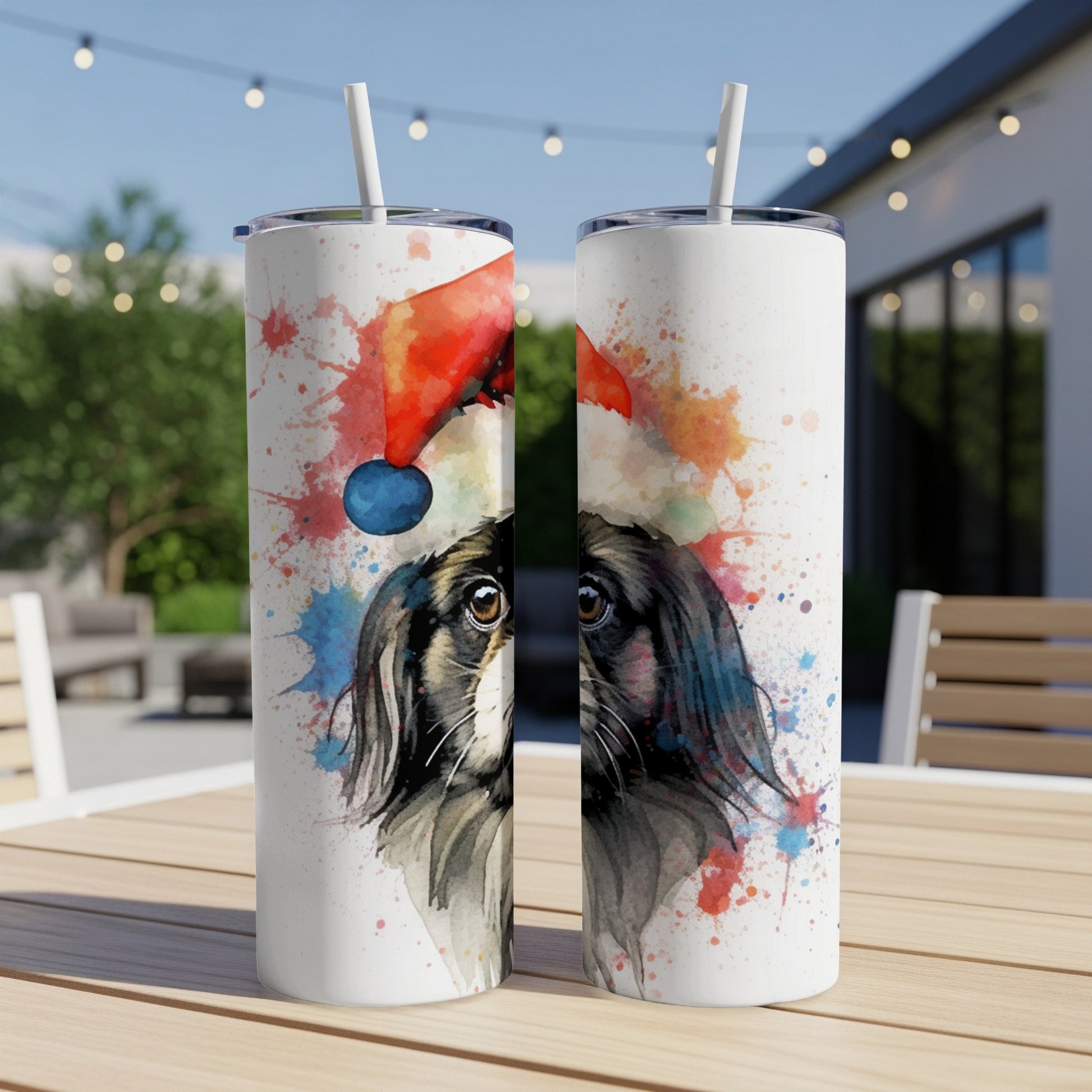 Two tumblers with a watercolor painting of a dog wearing a Santa hat.