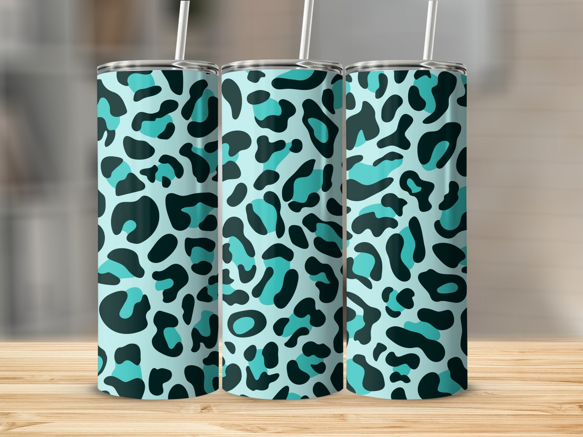 Three tall tumblers with a light blue background and black and teal leopard print.