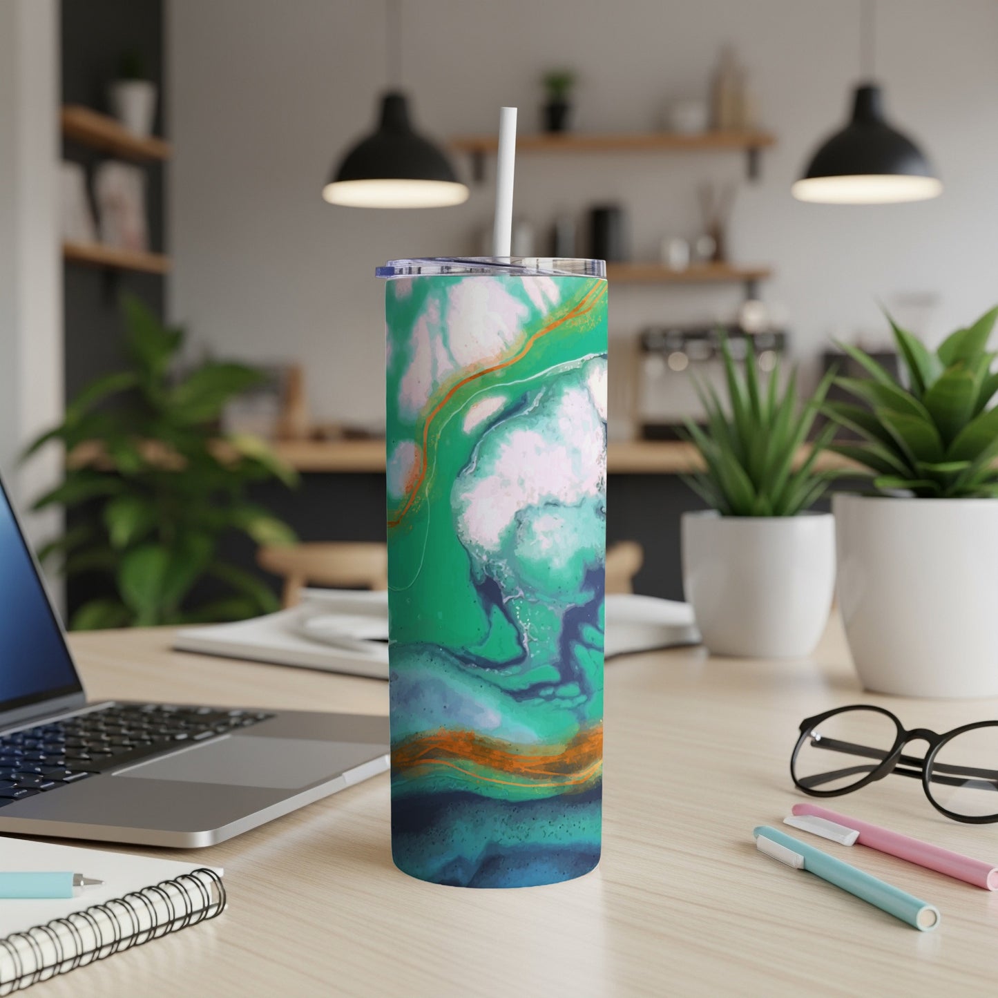 Tumbler with green, blue, and orange abstract fluid art design and white straw.
