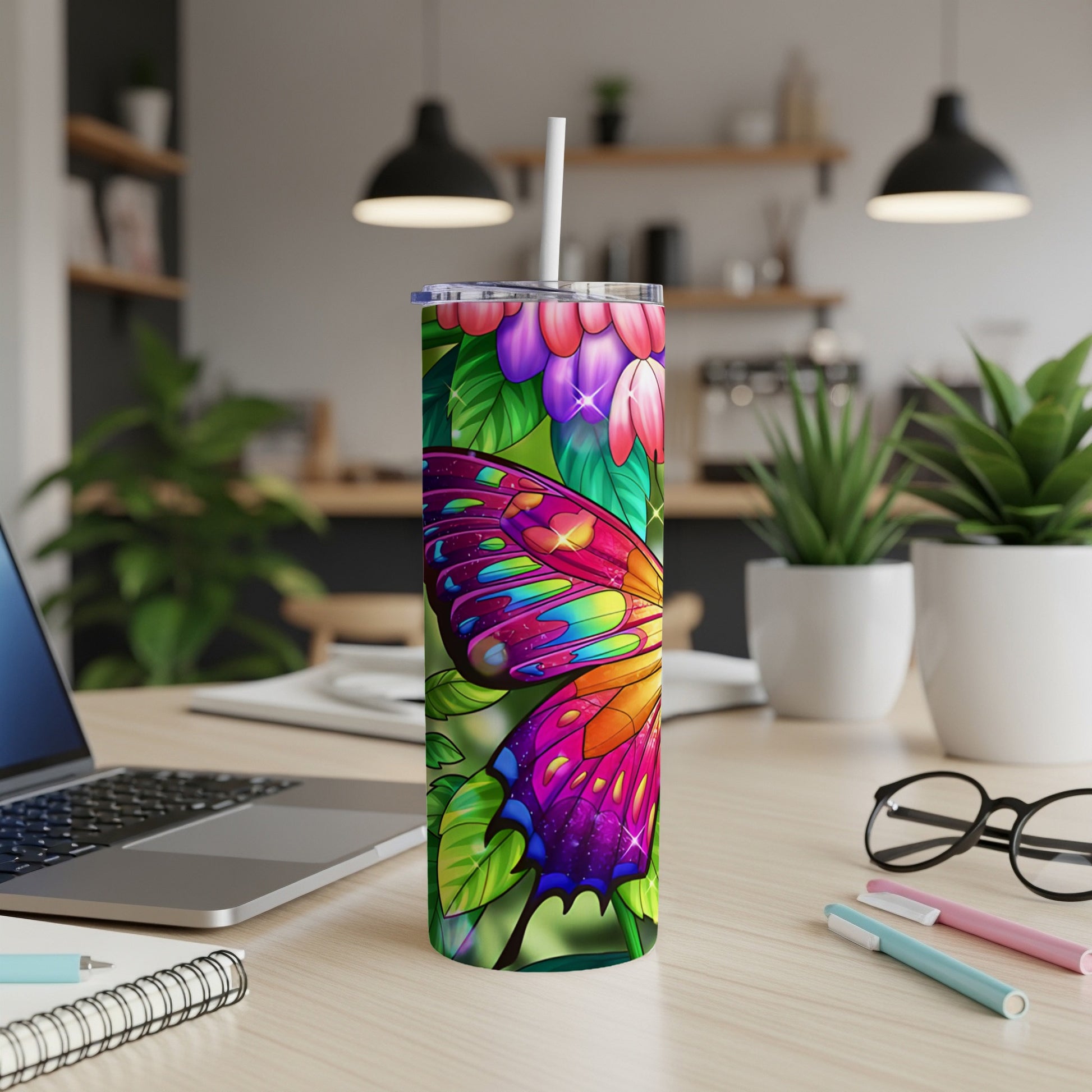 Tumbler with vibrant butterfly and floral design on a desk.