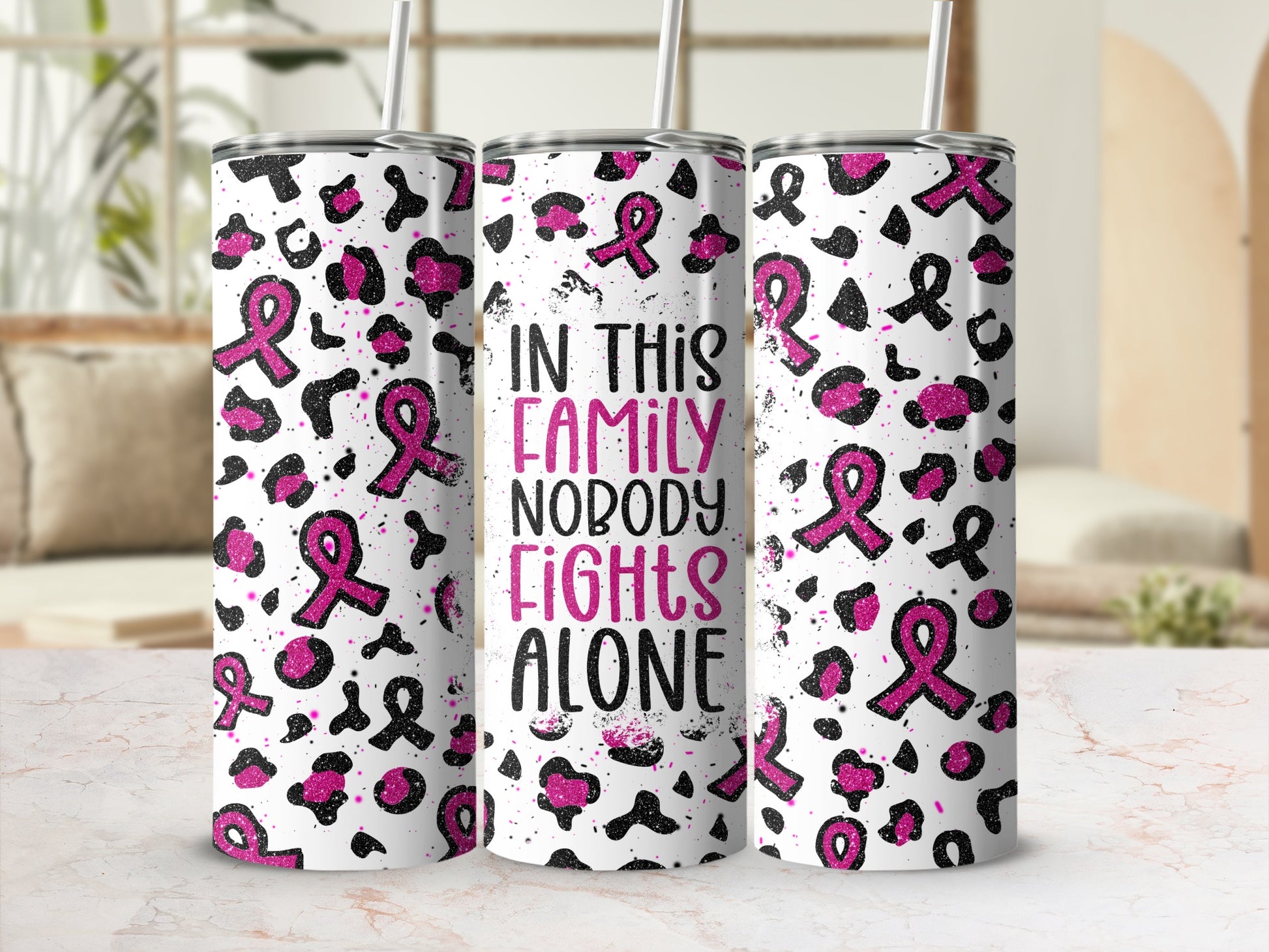 Tumbler with pink ribbons, leopard print, and "In this family nobody fights alone" text.