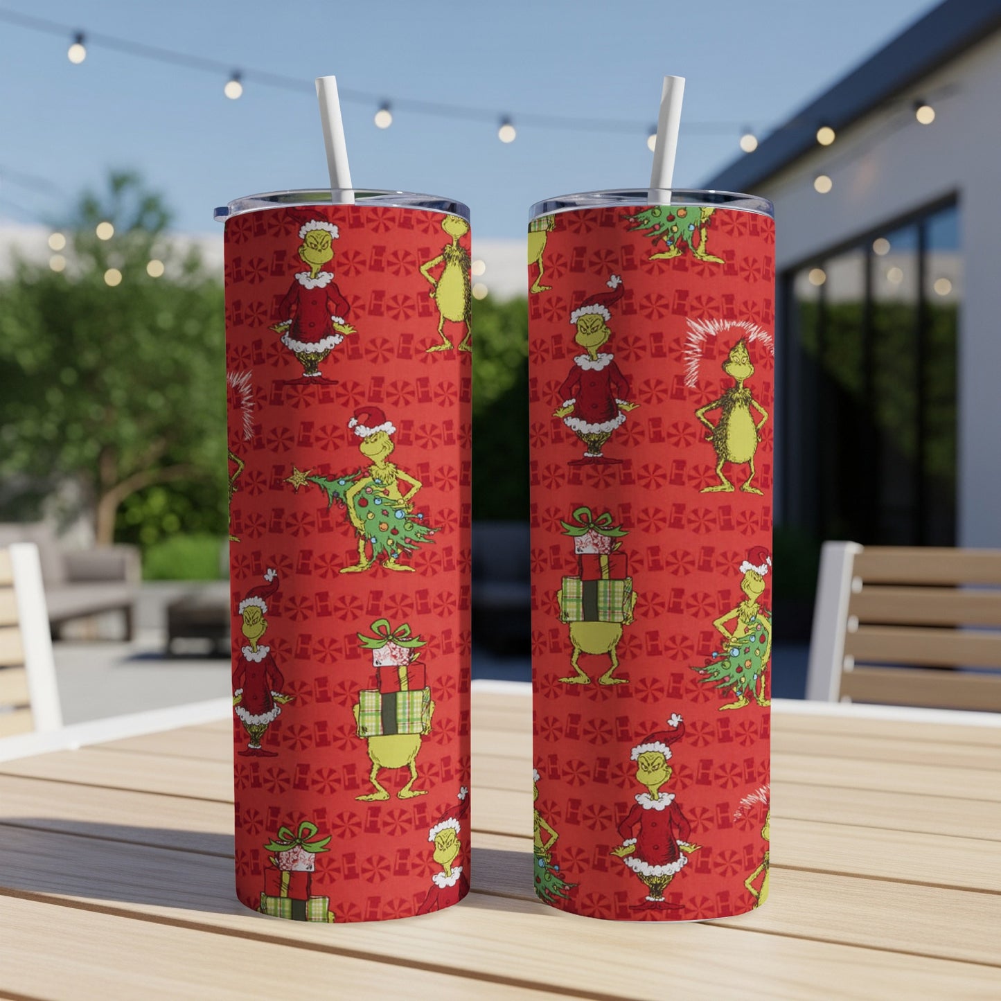 Two Grinch-themed tumblers with straws on a table, holiday pattern.