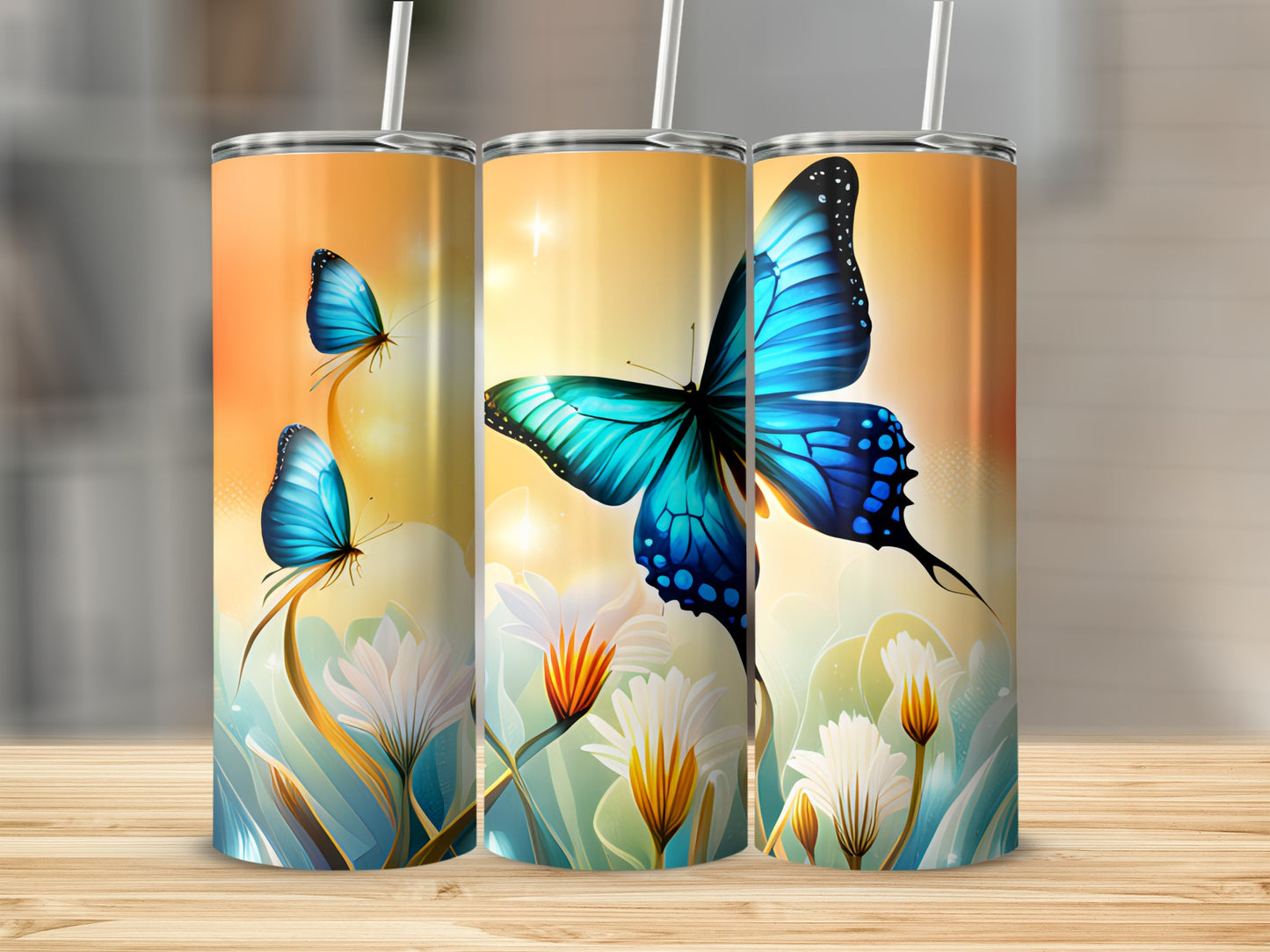 Three tumblers with blue butterflies and white flowers on a wooden surface.
