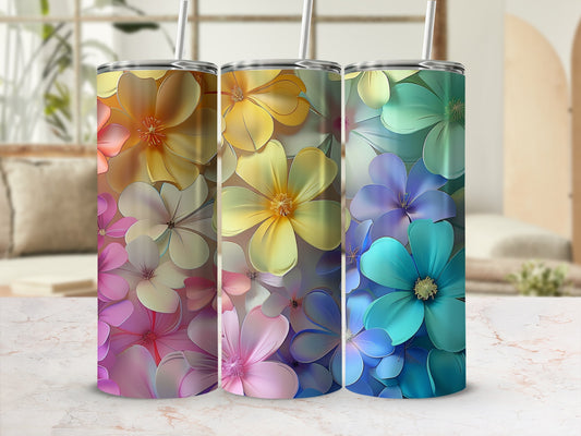 Three tumblers with colorful floral patterns and straws sit on a marbled surface.