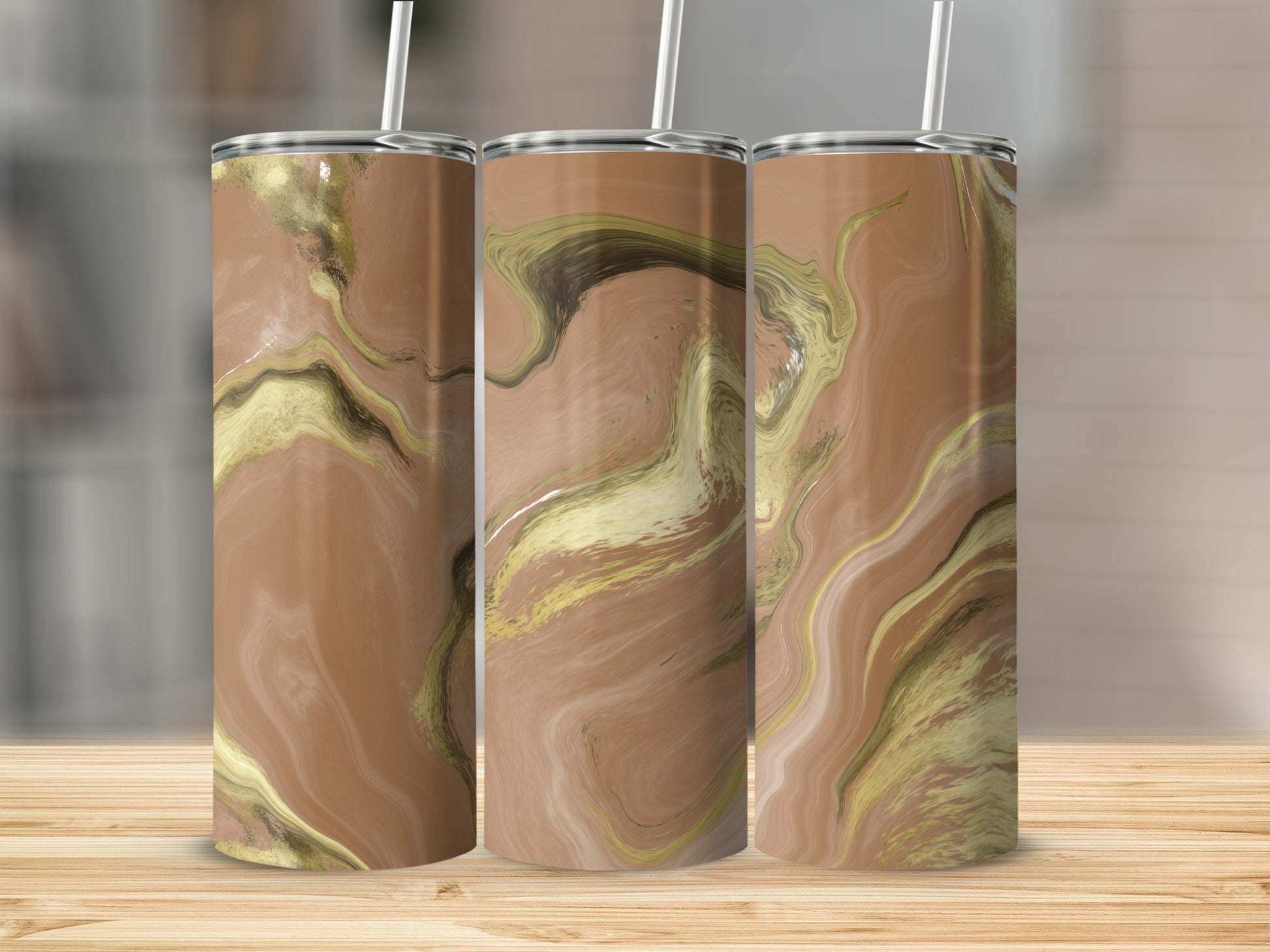 Three tumblers with a marbled brown and gold design stand on a wooden surface.