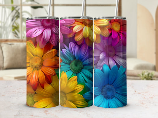 Three colorful floral tumblers with straws on a marbled surface.