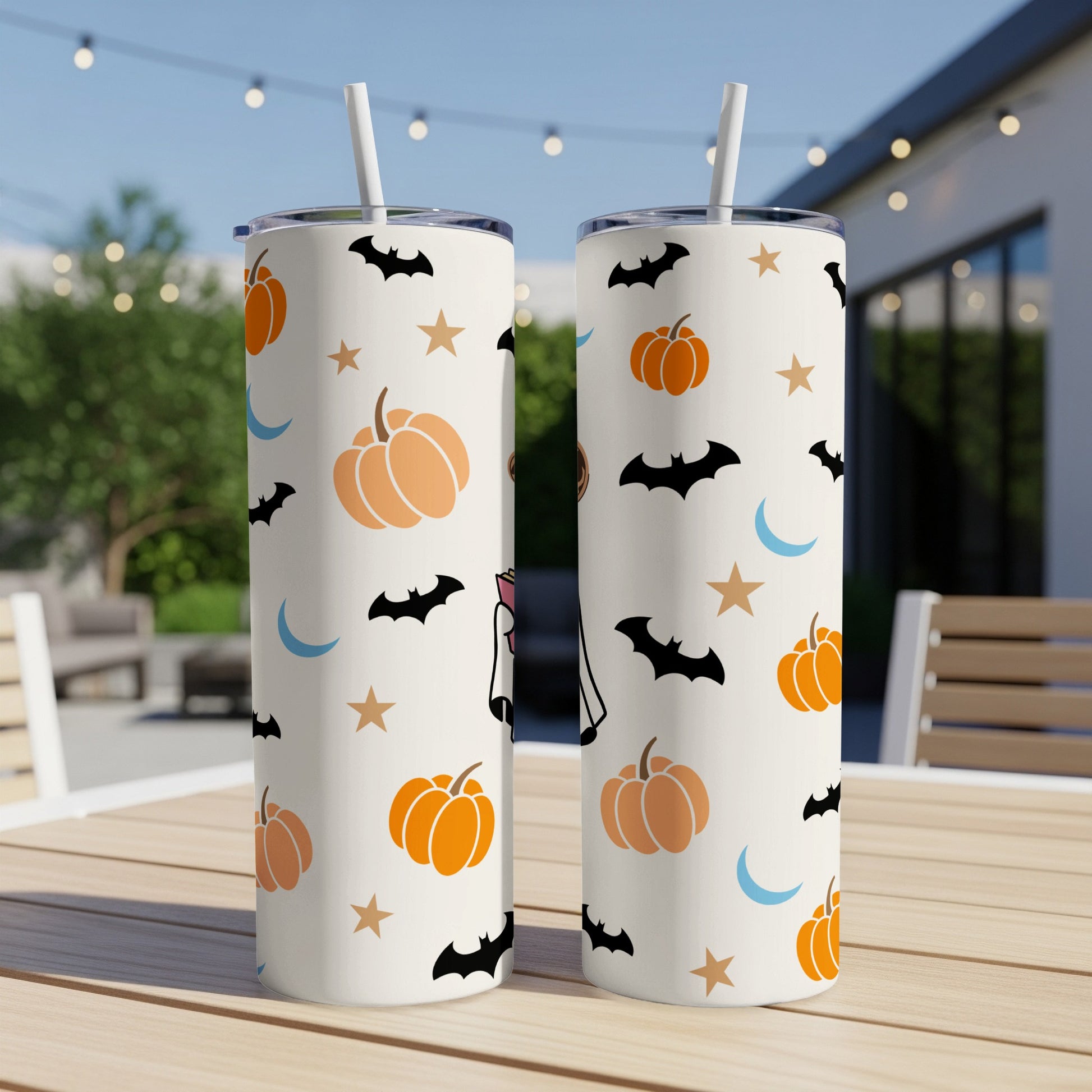 Two white tumblers with a Halloween pattern of pumpkins, bats, moons, and stars.