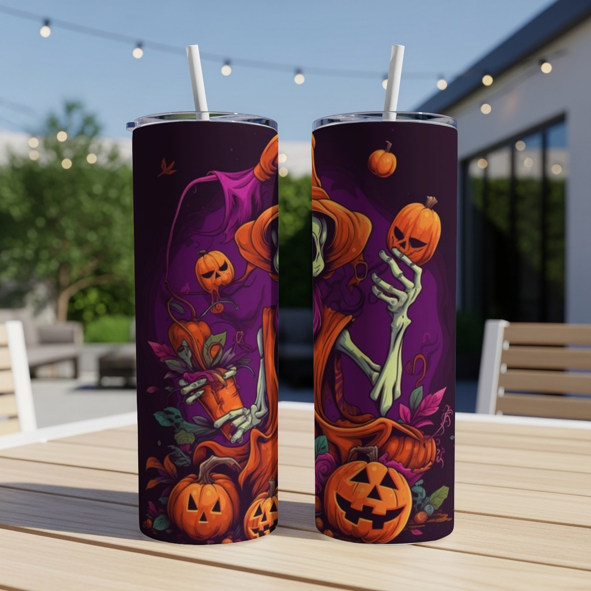 Two tumblers with Halloween skeleton and pumpkin artwork on a wooden table outdoors.