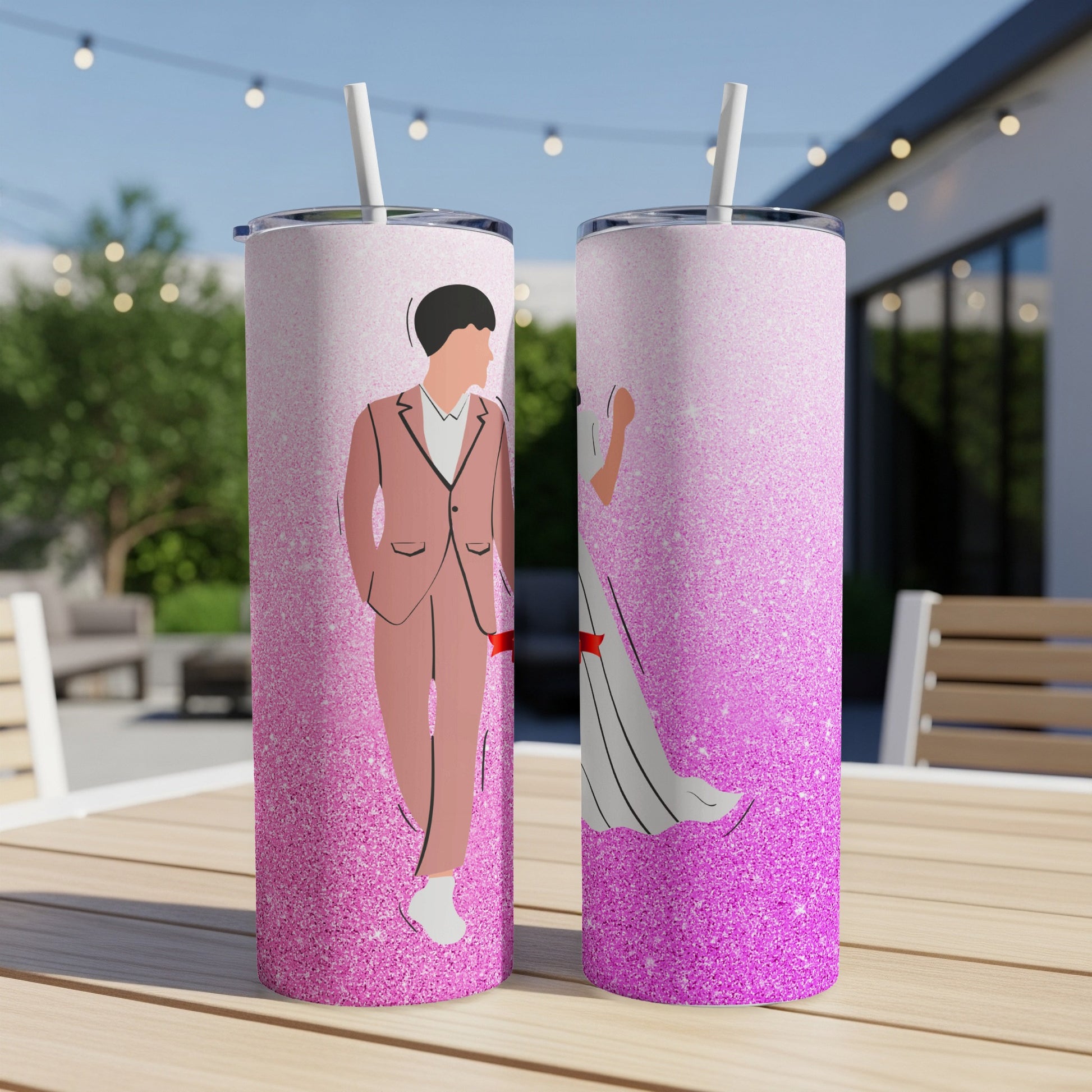 Two tumblers with couple illustration on a table outdoors.