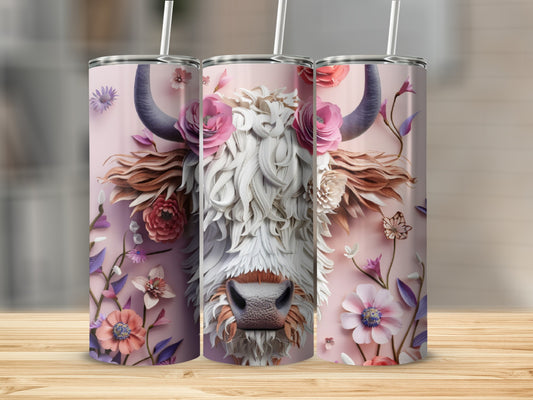 Pink floral highland cow tumbler with straw on a wooden surface.