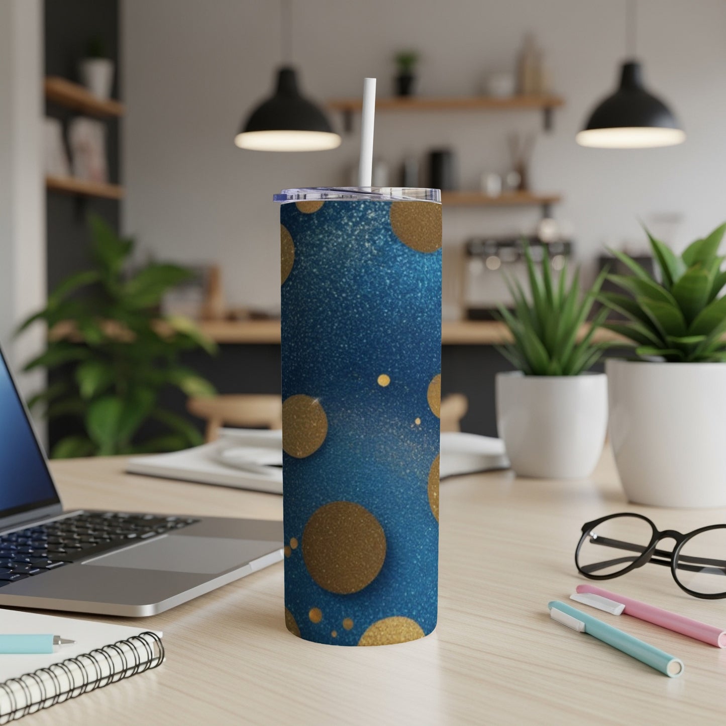 Blue tumbler with gold glitter circles, straw, and laptop.