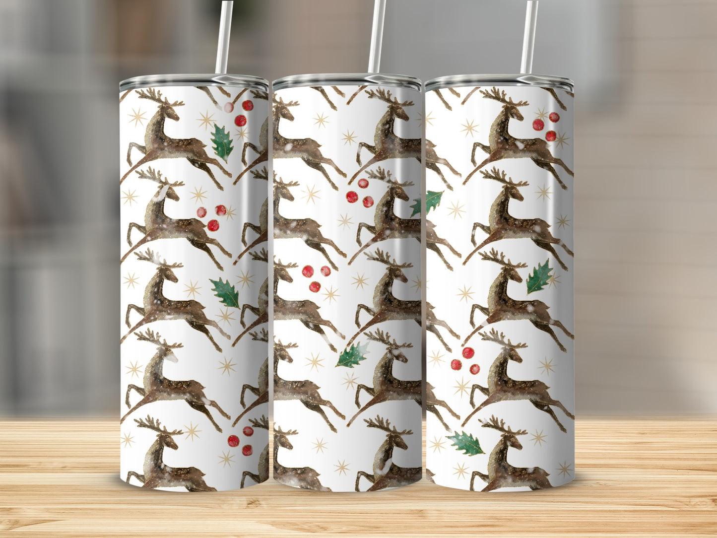 Three tumblers with a watercolor reindeer and holly pattern.