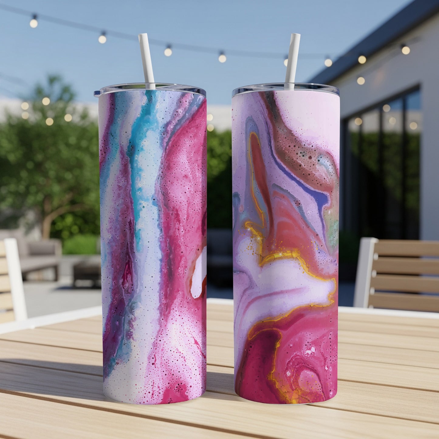 Two tumblers with abstract pink and blue marble designs stand on a wooden table.