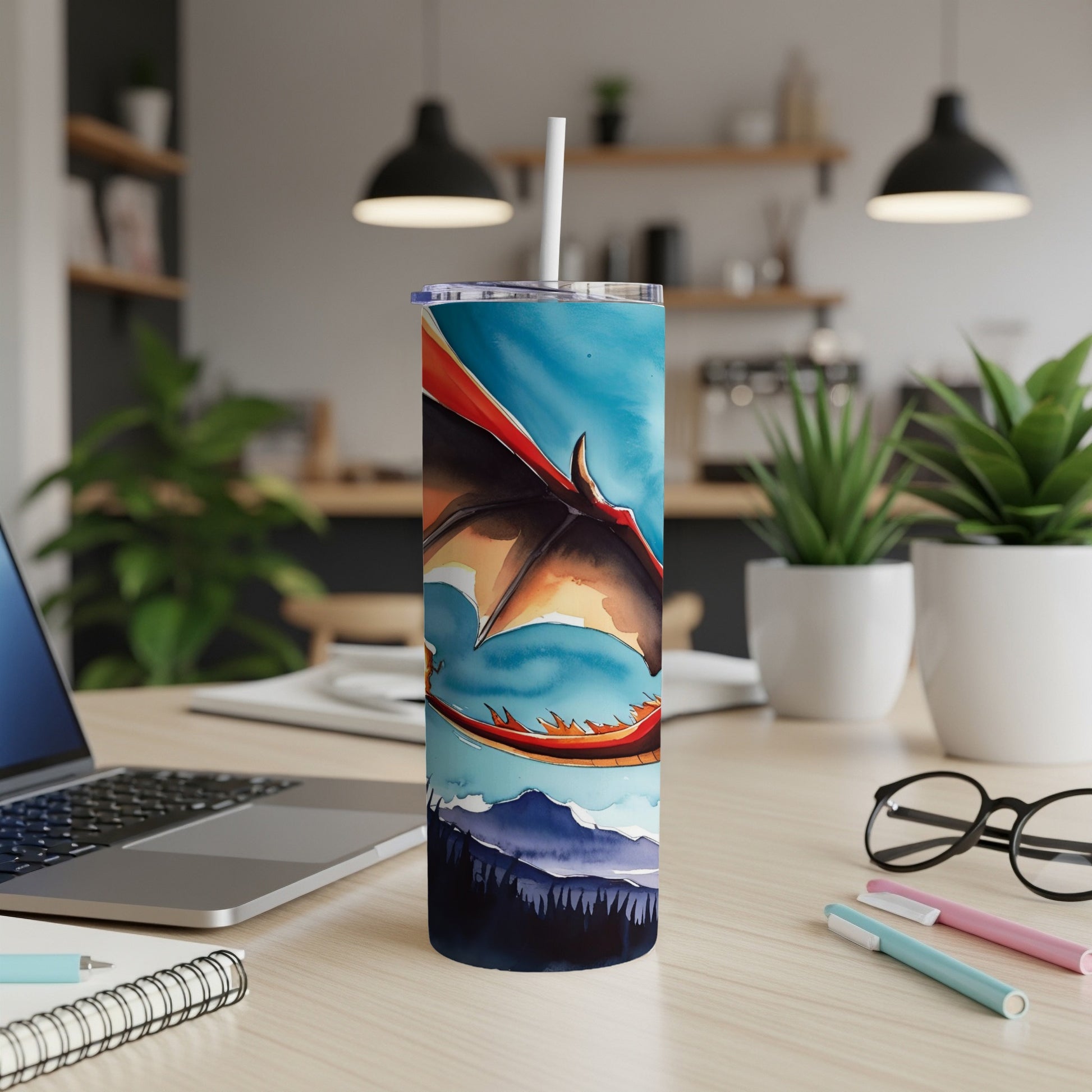 Dragon artwork on a blue tumbler with a mountain landscape background.