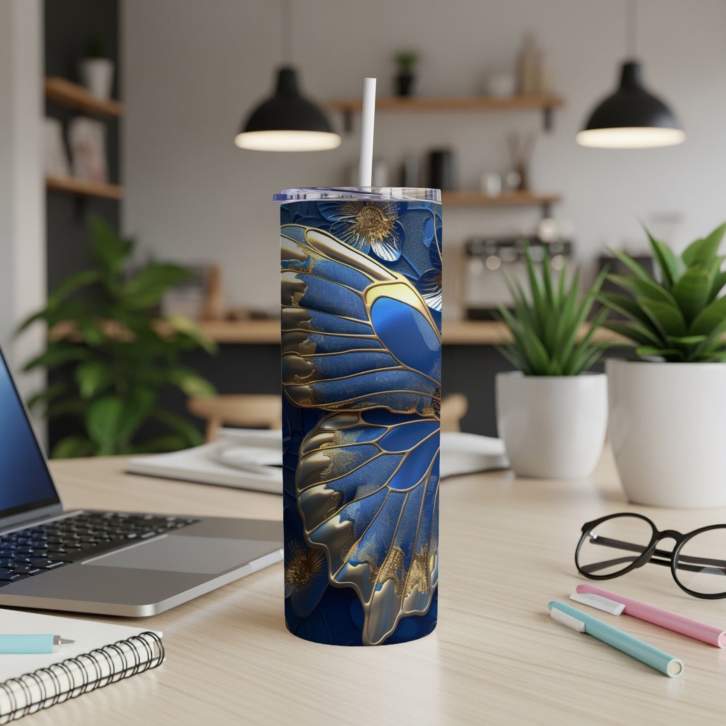 Blue butterfly wing design on a tall, slim tumbler with a straw.