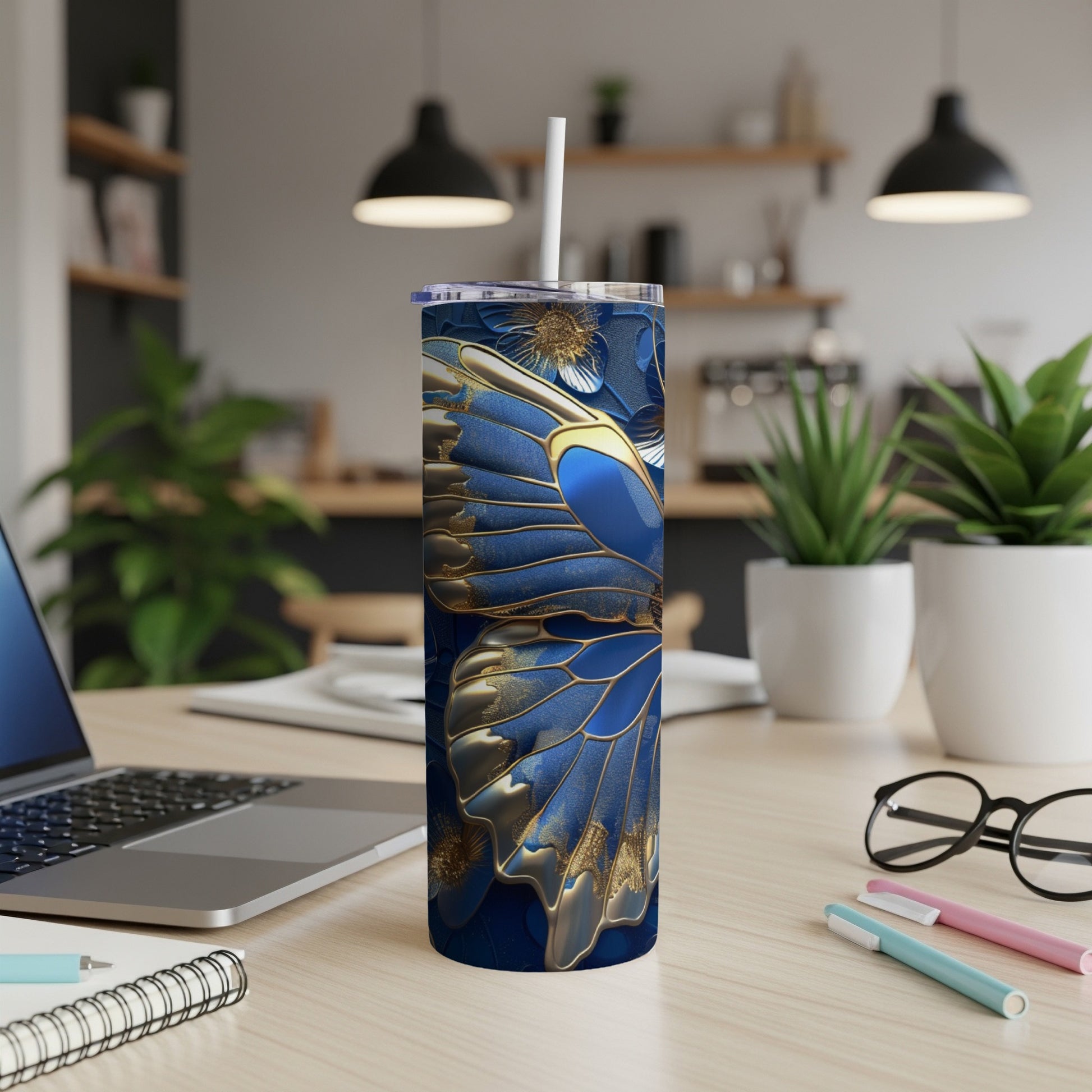 Blue butterfly wing design on a tall, slim tumbler with a straw.