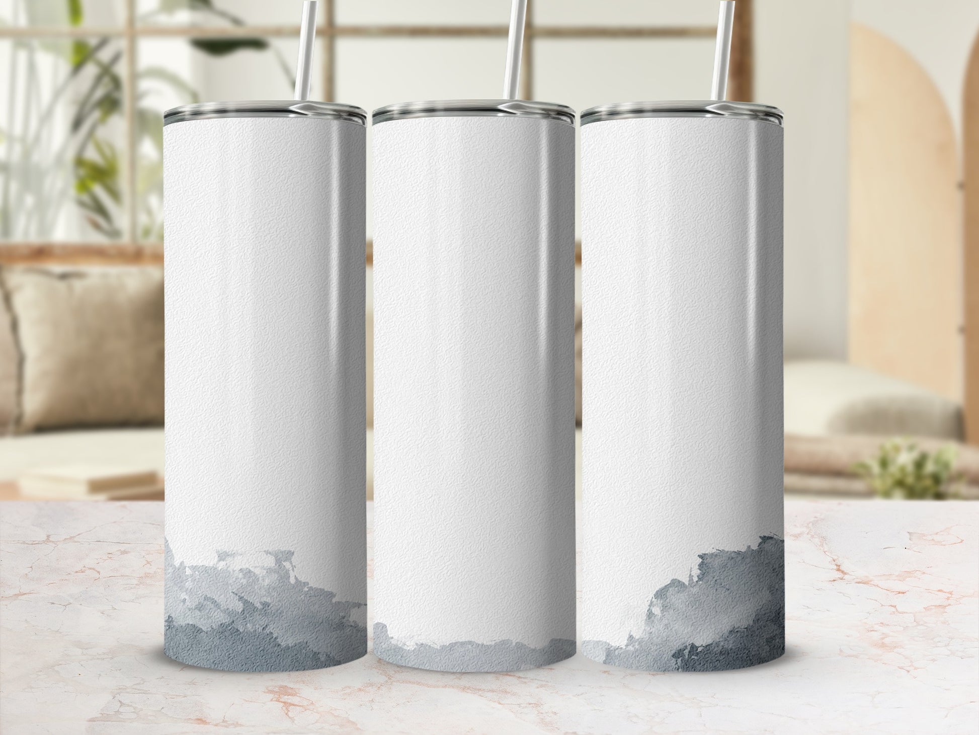 Three white tumblers with gray watercolor designs and straws, on a marble surface.