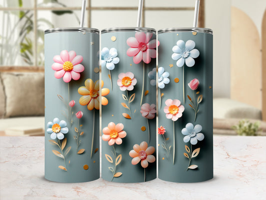 Three tumblers with colorful flowers and sprigs on a dusty blue background.