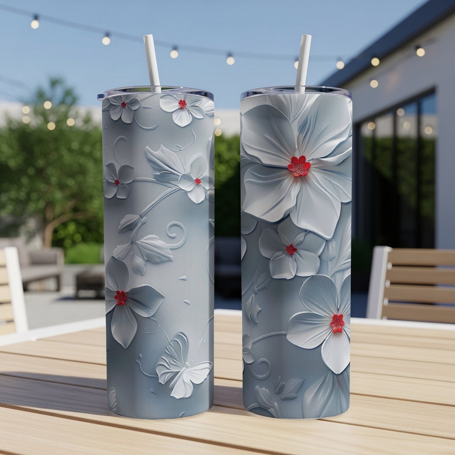 Two gray tumblers with white floral and butterfly designs and red flower centers.