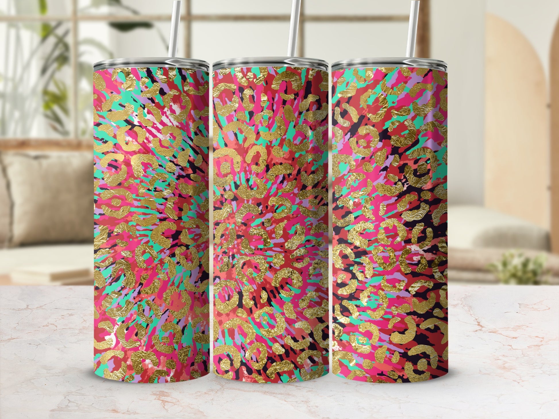 Three tumblers with a gold leopard print and abstract colorful design.