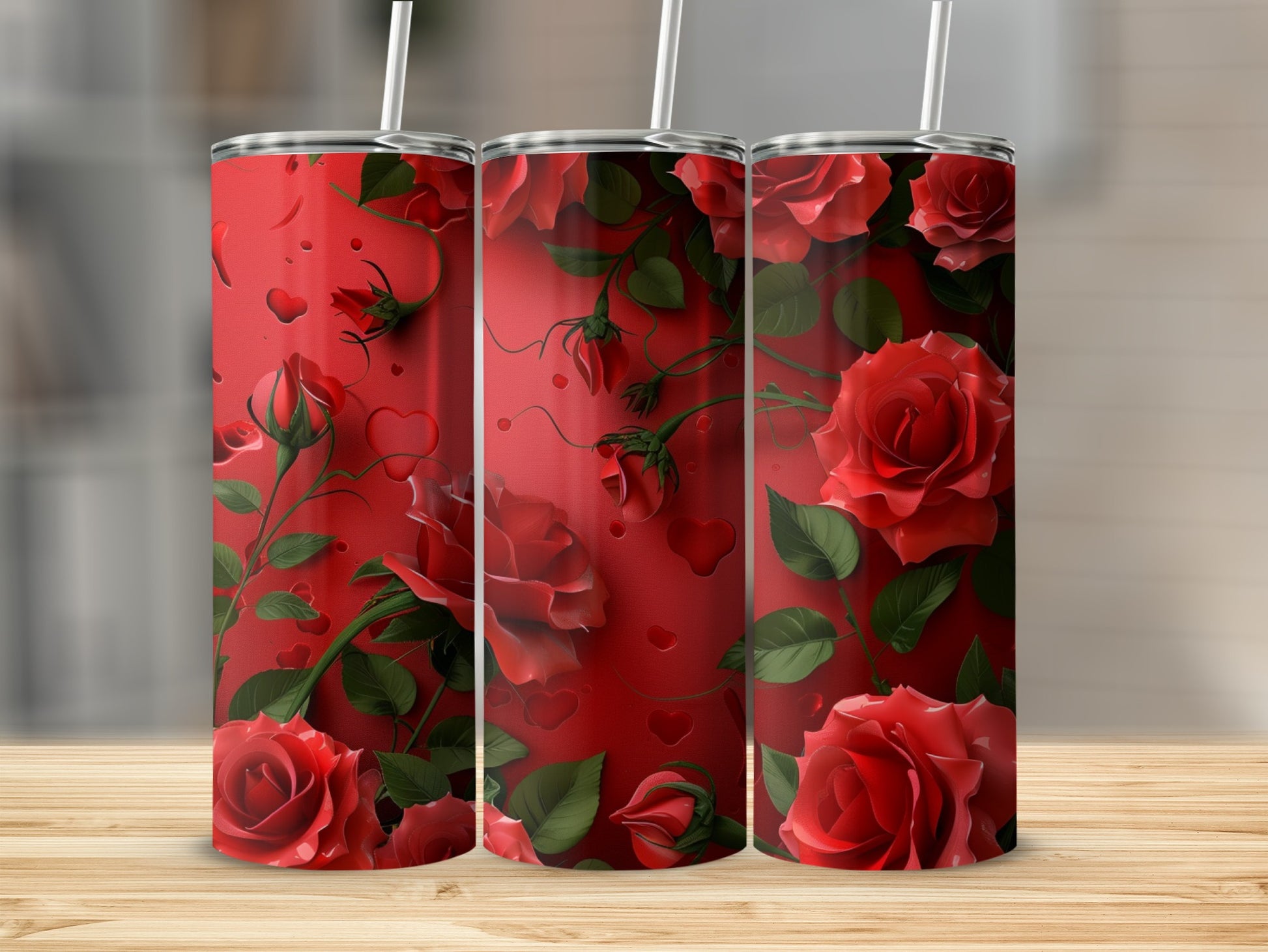 Three red rose tumblers with hearts and vines on a wooden surface.
