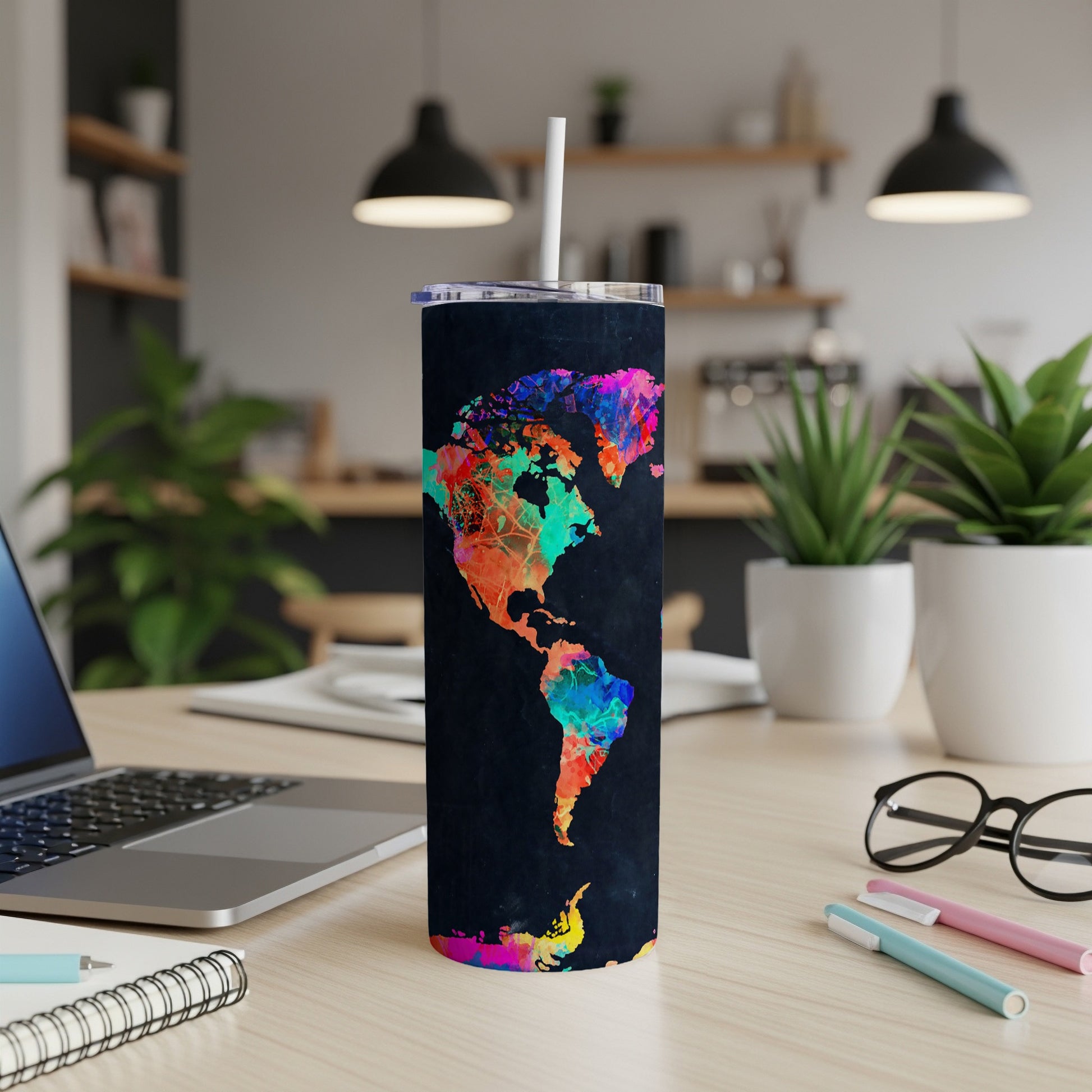 Black tumbler with colorful abstract North and South America map design and white straw.