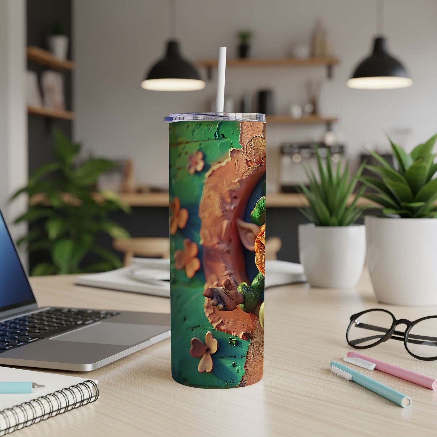 Green tumbler with shamrocks and a gnome, on a desk.
