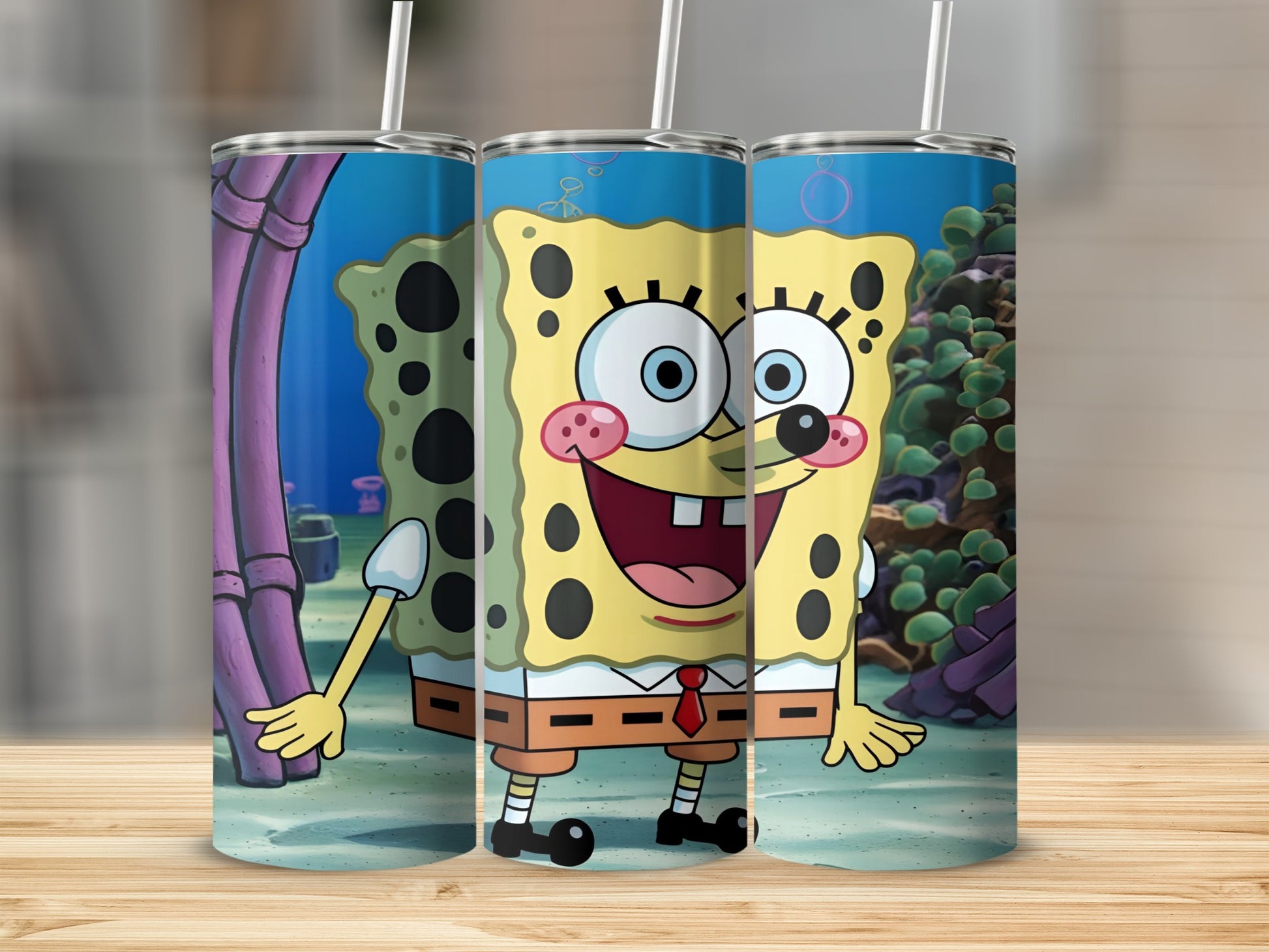 SpongeBob SquarePants character with coral reef background on three tumblers.