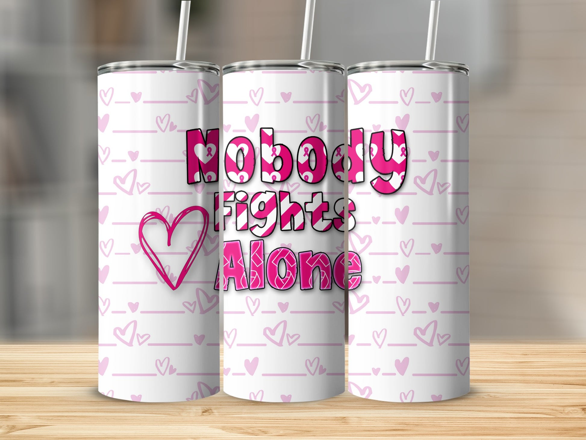 Pink tumbler with "Nobody Fights Alone" text and heart pattern.