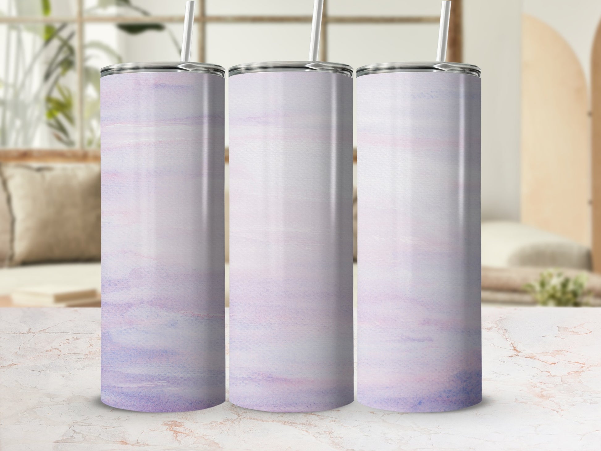 Three tall tumblers with a pastel watercolor design on a marbled surface.