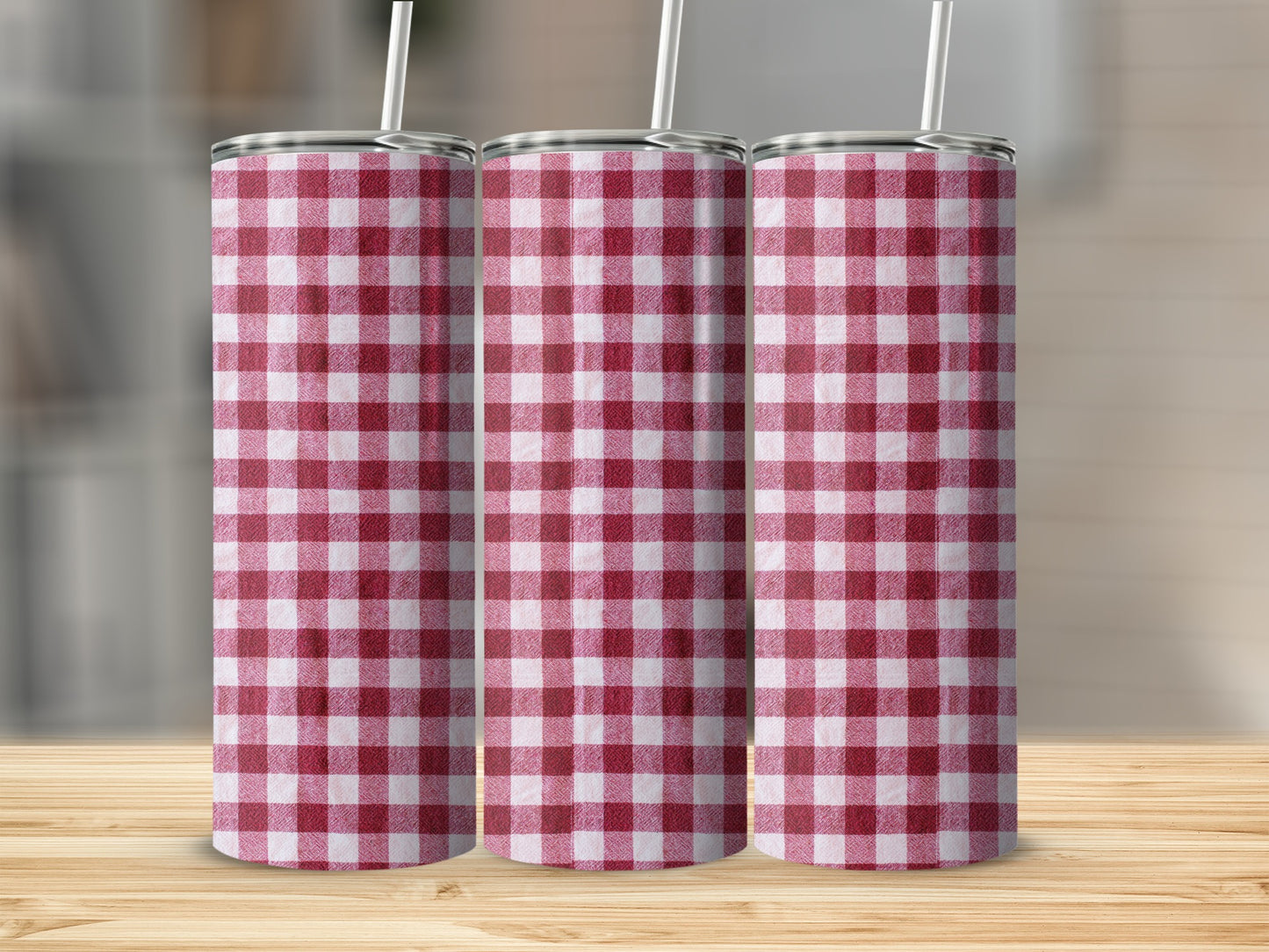 Three tumblers with red and white gingham pattern, standing on a wooden surface.