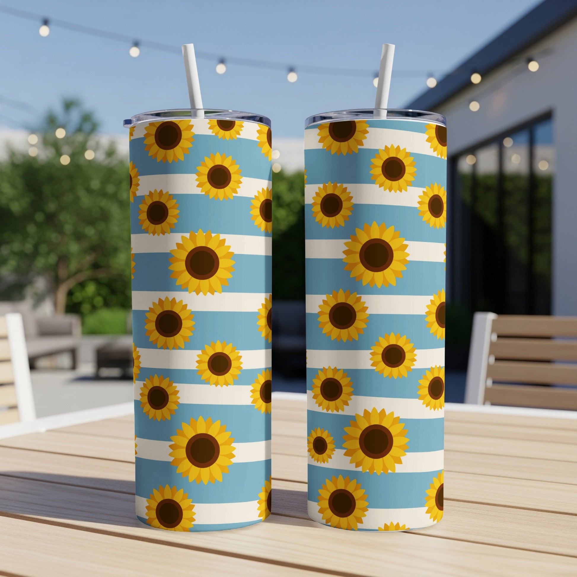 Two tumblers with sunflowers on a blue and white striped pattern.
