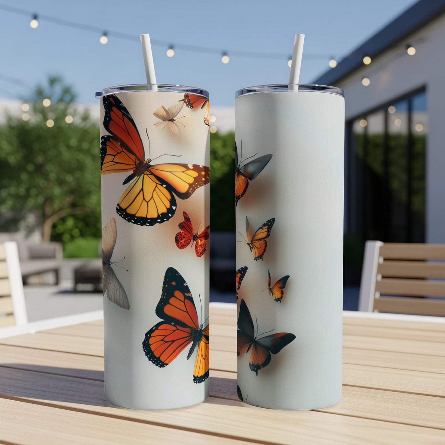 Two tall, skinny tumblers with colorful butterfly graphics on a wooden table.