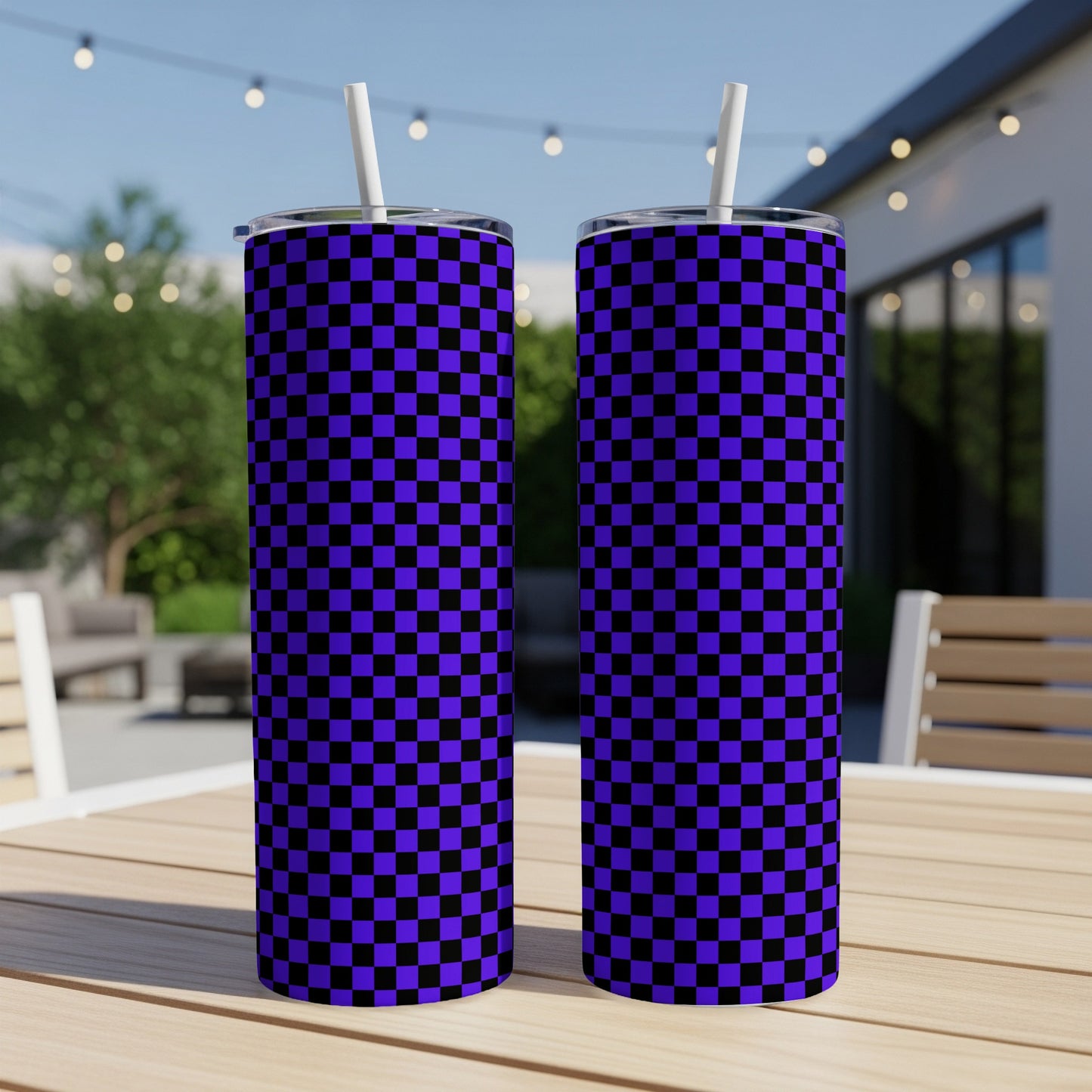 Two purple and black checkered pattern tumblers with straws on a table.