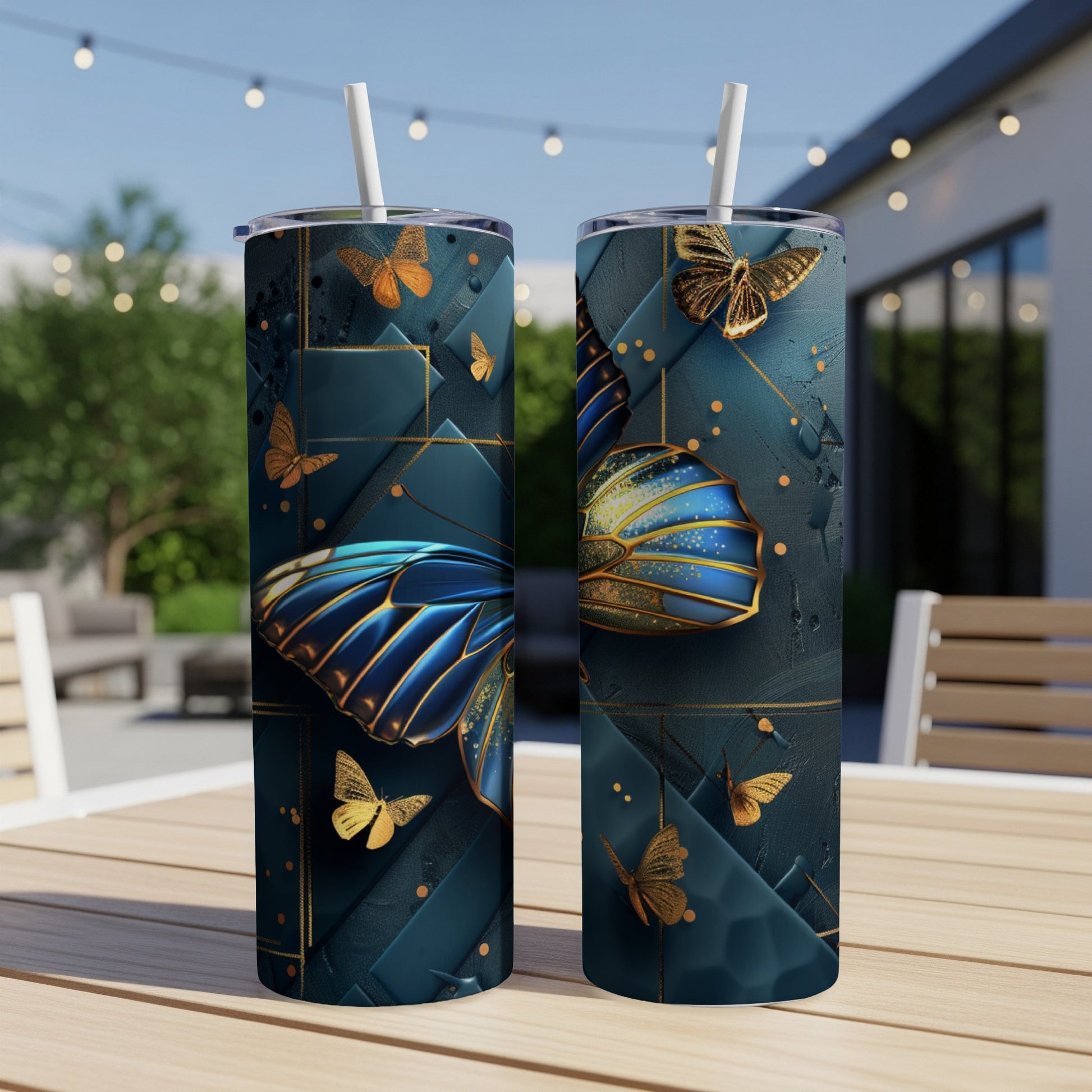 Two tumblers with ornate gold and blue butterfly design on a patio table.