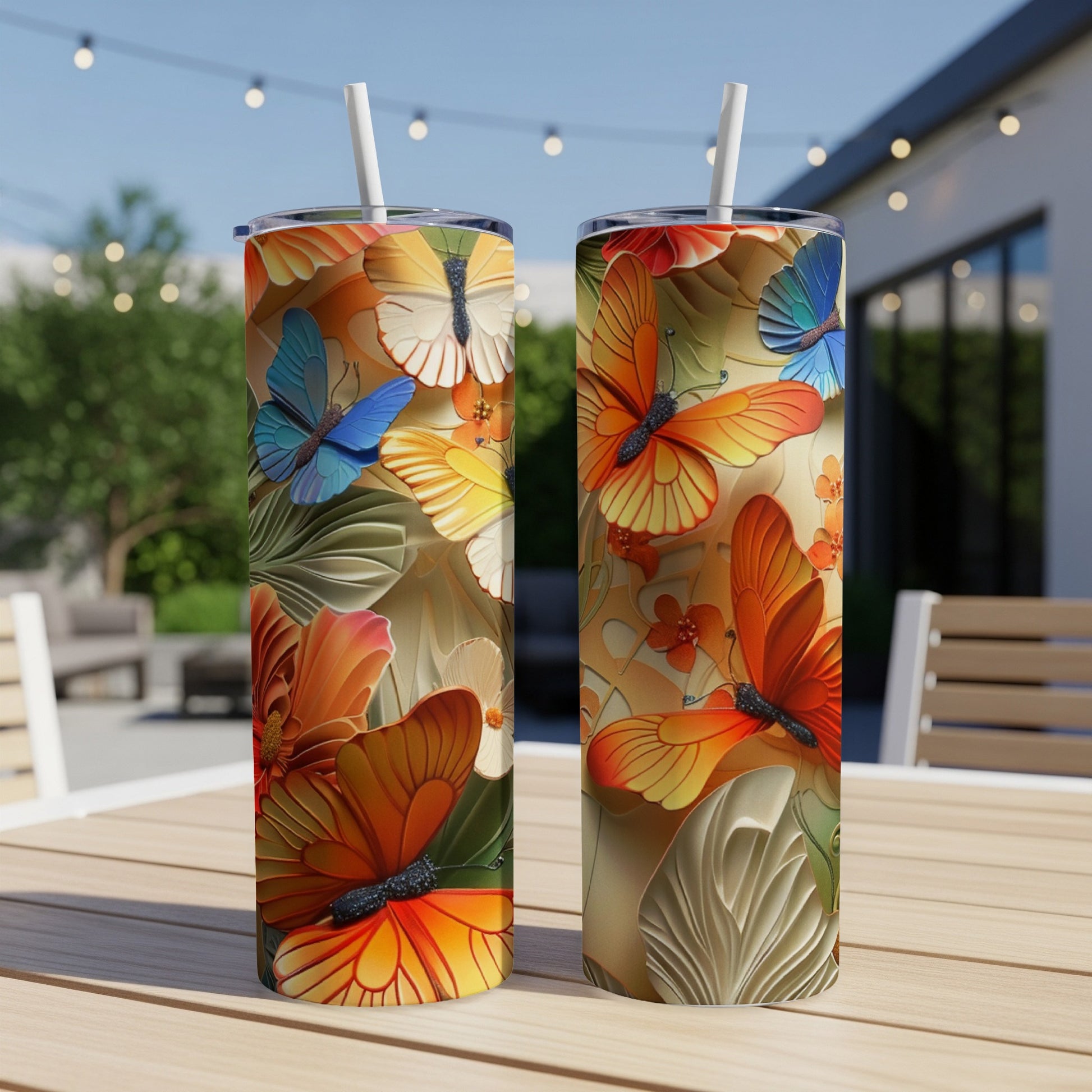 Two tall tumblers with orange and yellow butterflies and floral designs.