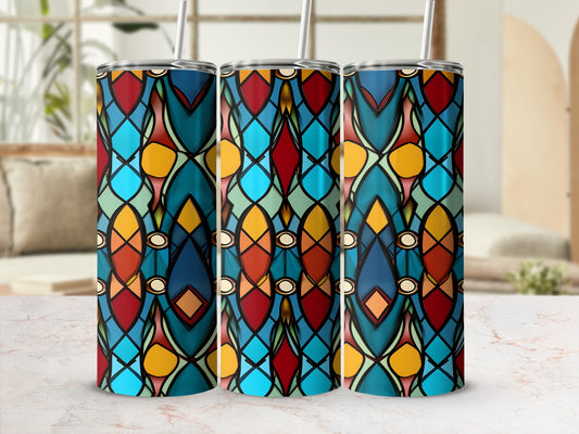 Three stained glass tumblers with colorful geometric patterns on a marble surface.