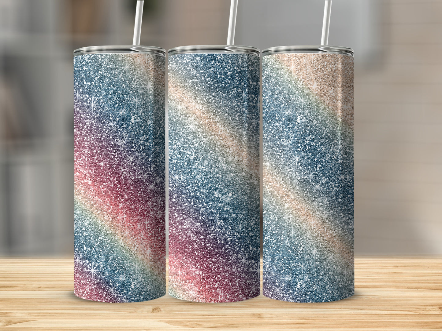 Three skinny tumblers with a glittery rainbow stripe pattern and straws.