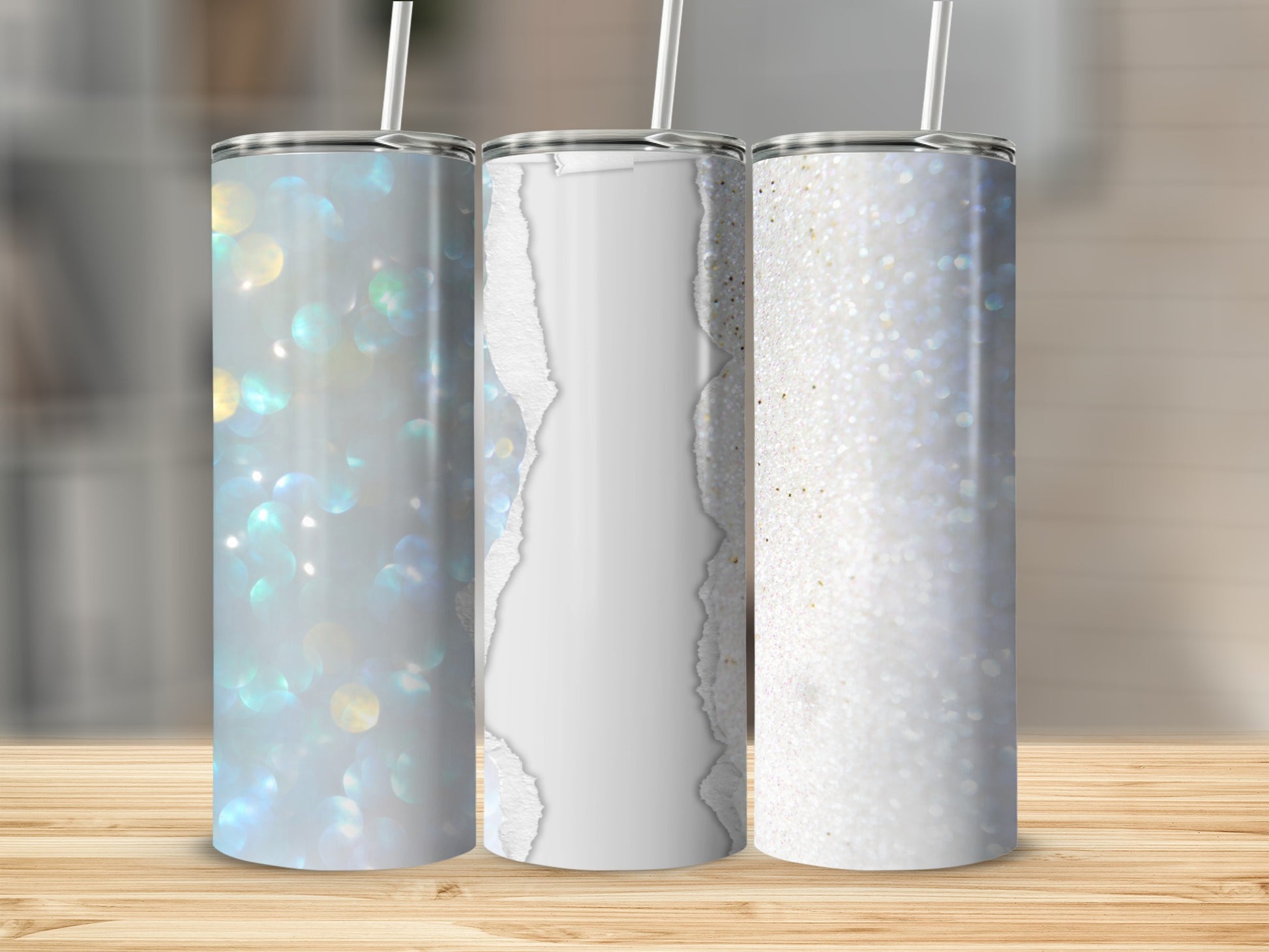 Three tumblers with glittery and ripped paper designs on a wooden surface.