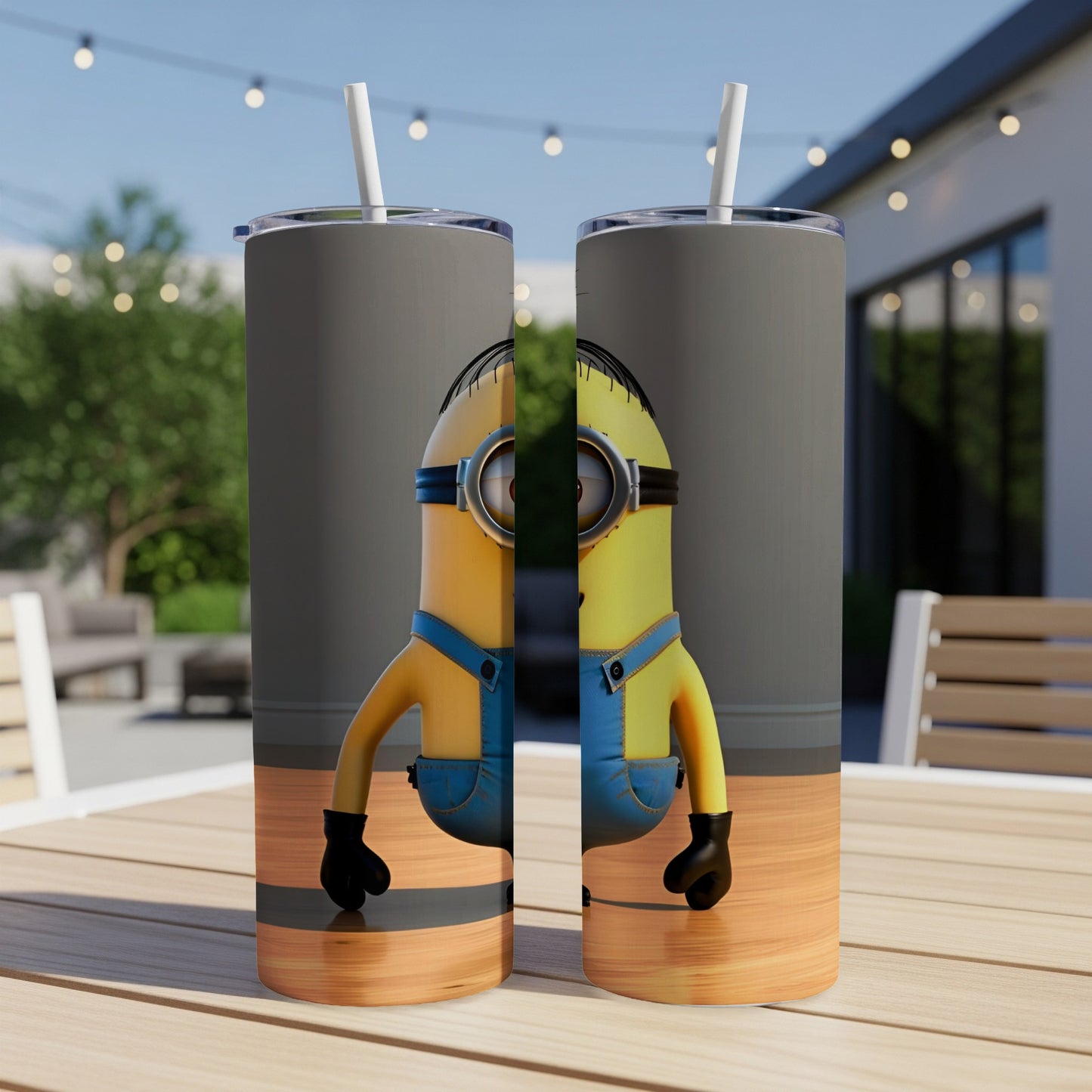 Two Minion tumblers with straws on a wooden table.