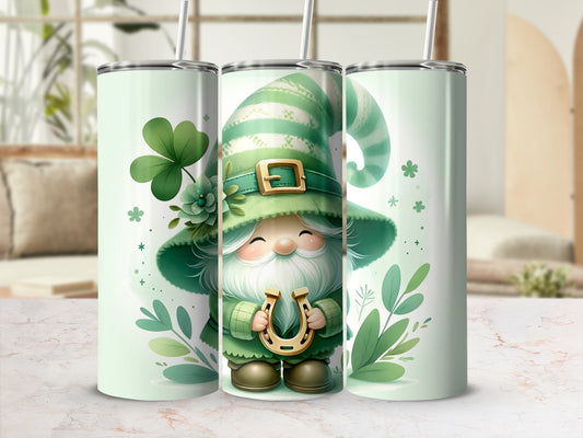Green gnome with horseshoe on a patterned tumbler, surrounded by shamrocks and leaves.