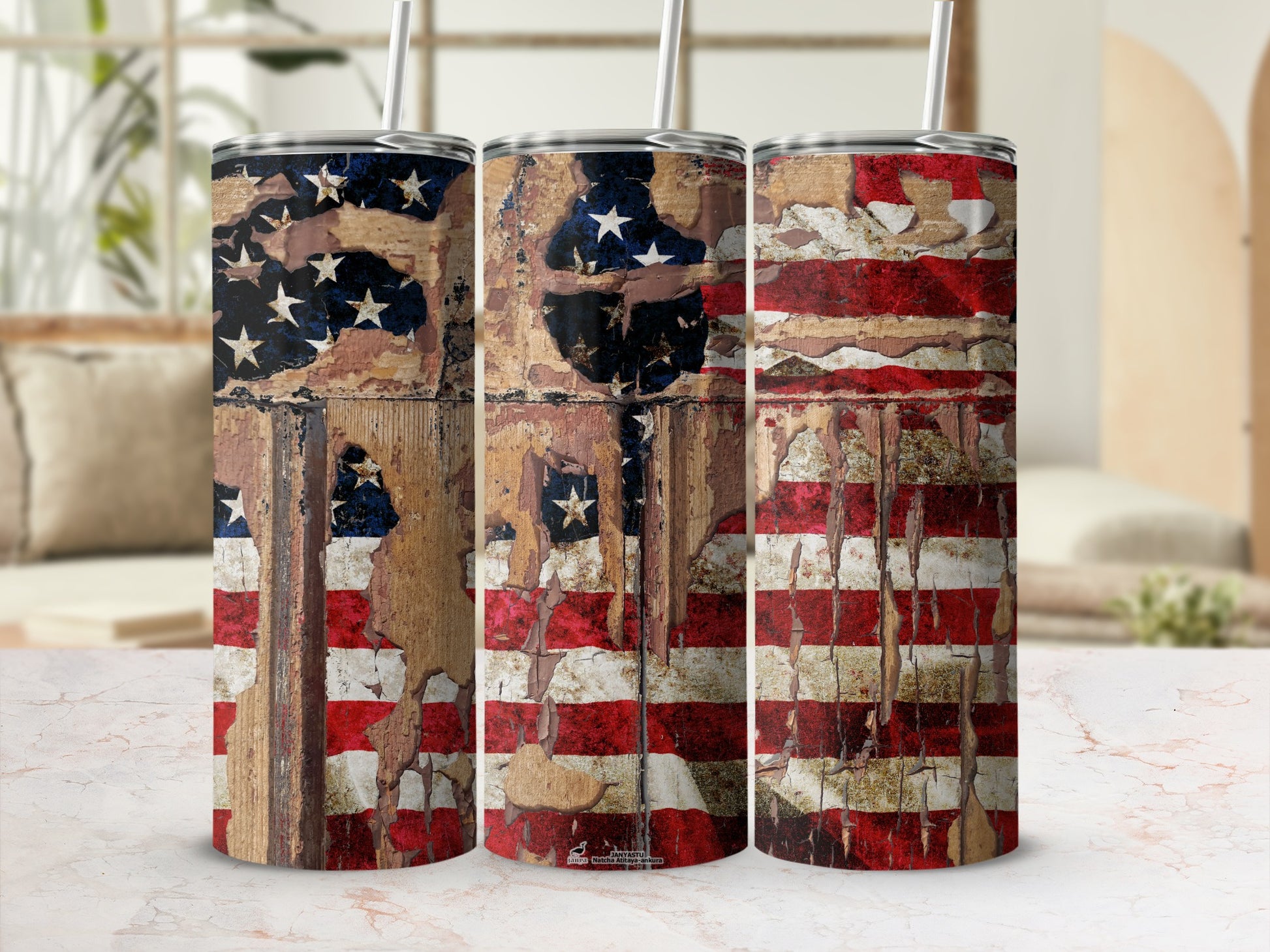 Three tumblers with distressed American flag design and straws, on a marbled surface.