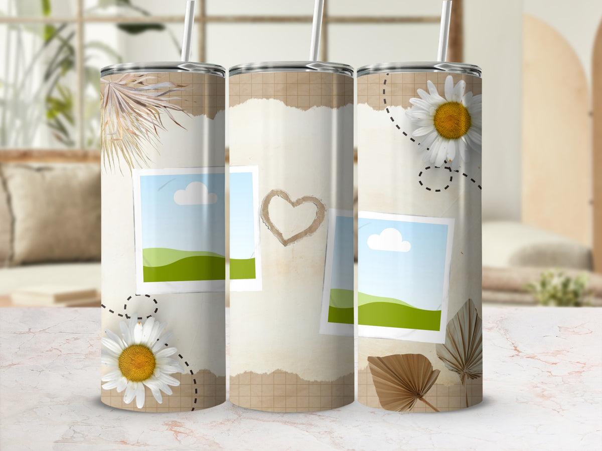 Tumbler with torn paper, flowers, and photo placeholders on a marble surface.