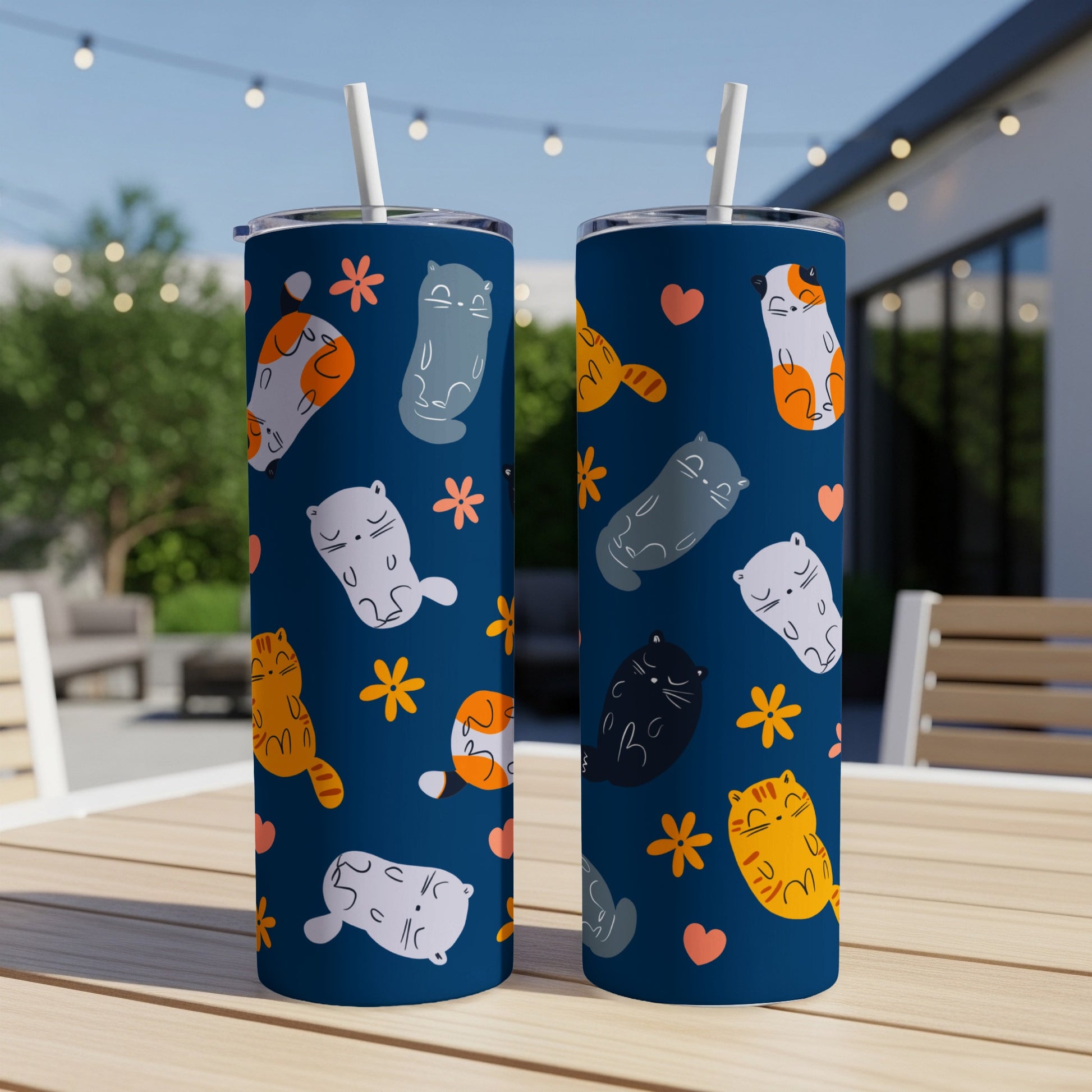 Two blue tumblers with repeating cat and flower pattern.
