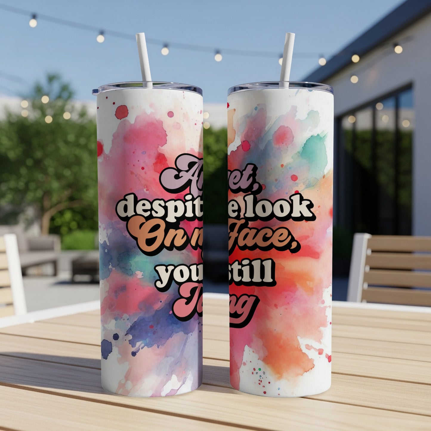Tumbler with colorful watercolor splash and text "at least look on your face, you still thing".