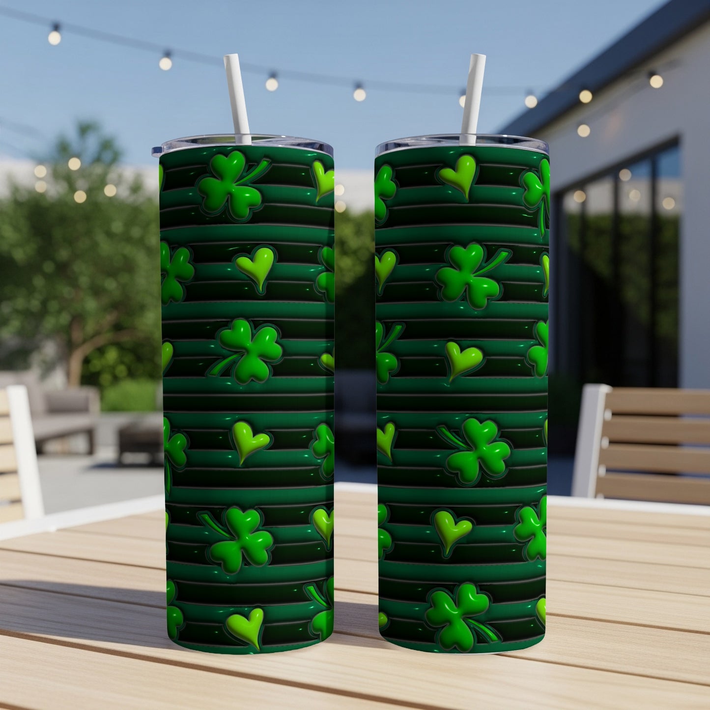 Two green tumblers with shamrock and clover patterns on a table.