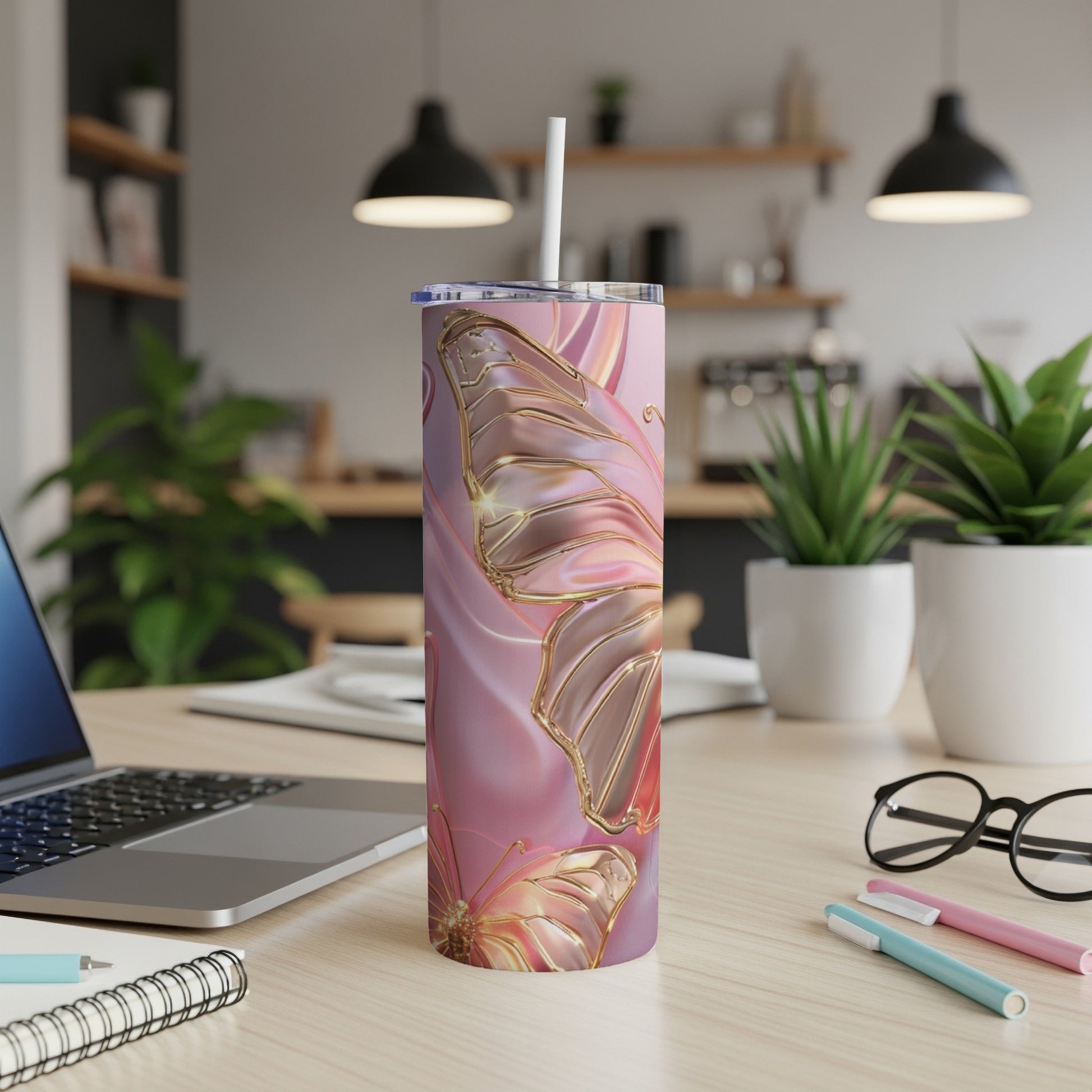 Pink butterfly tumbler with gold accents on a desk.