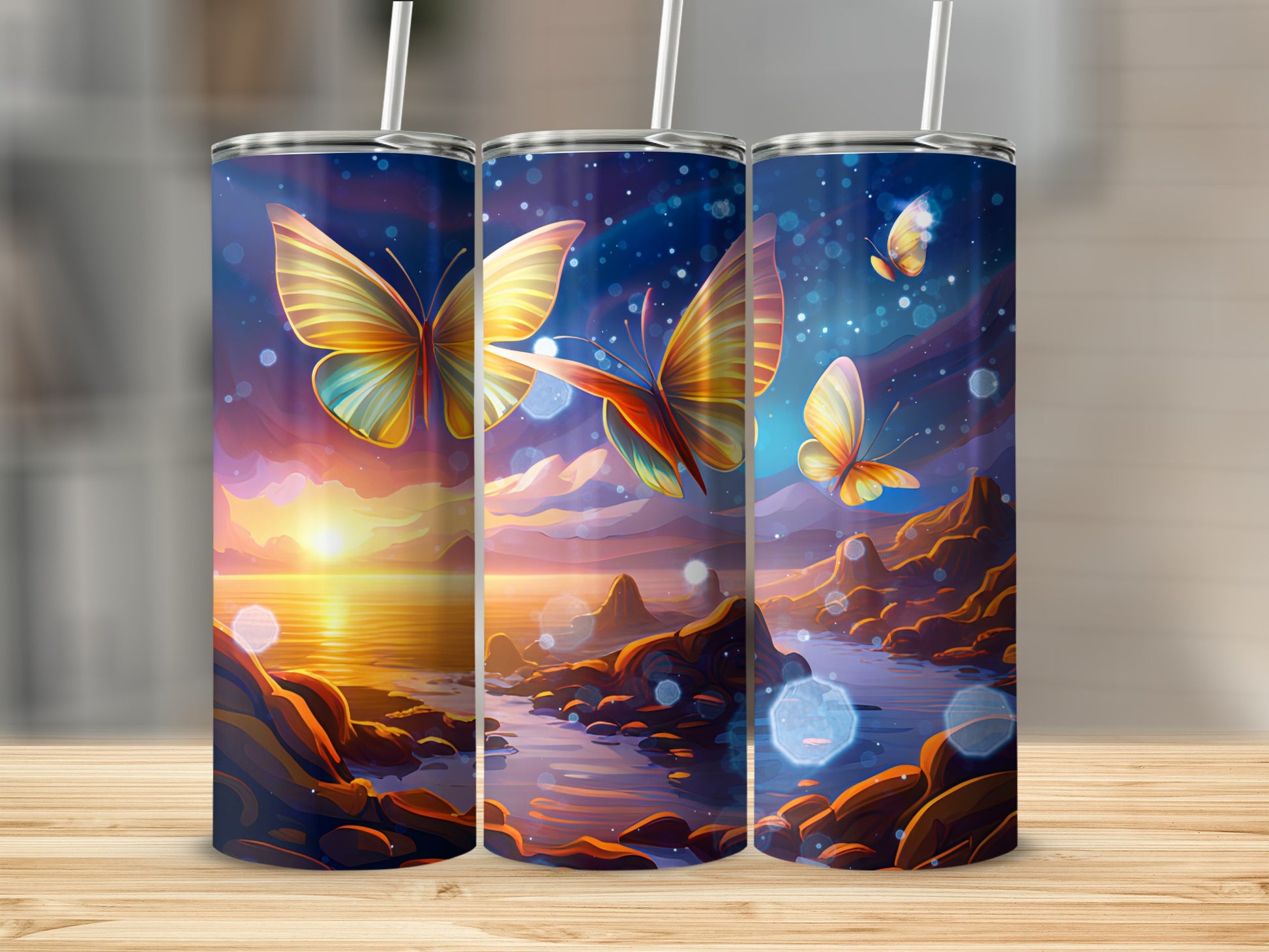 Three tumblers with butterflies and sunset landscape designs.