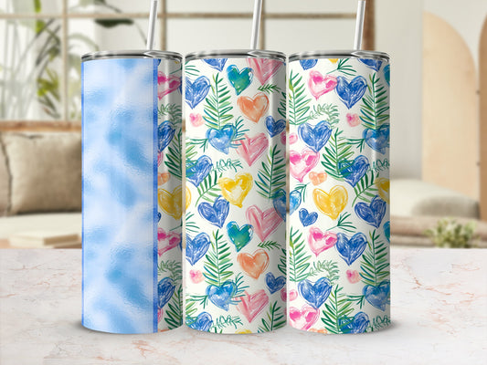 Three tumblers with heart and leaf patterns on a marble surface.
