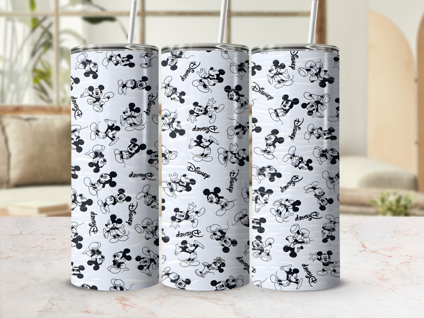Three Disney Mickey Mouse tumblers with straw, patterned with black and white Mickey Mouse figures and "Disney" text.
